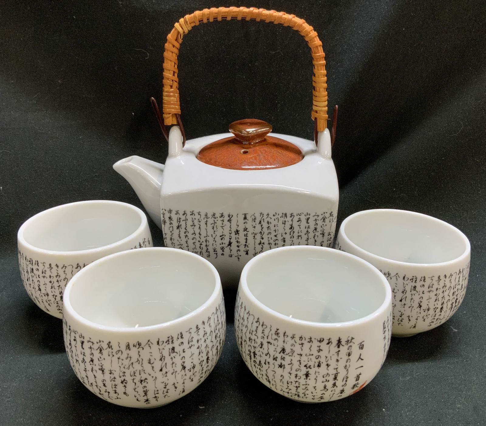 Set 5 Japanese Calligraphy Porc Teapot & Cups: Lot includes, set 5 Japanese tea set that includes a teapot & four cups. Body of teacup & cups feature black calligraphy. Porcelain material. Surface wear consistent to age, use & exposure. Property o