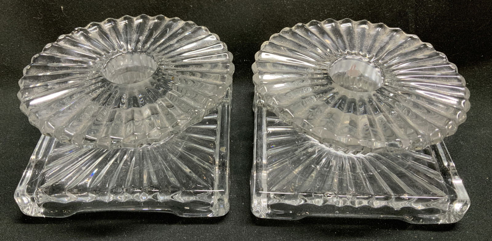 Pair Vtg Clear Crystal Ribbed Candle Holders: Lot includes, a pair of vintage crystal candle holders featuring a ribbed pattern & square base. Round top. Surface wear consistent to age, use & exposure. Measurements: length 3.7in x width 3.5in x h