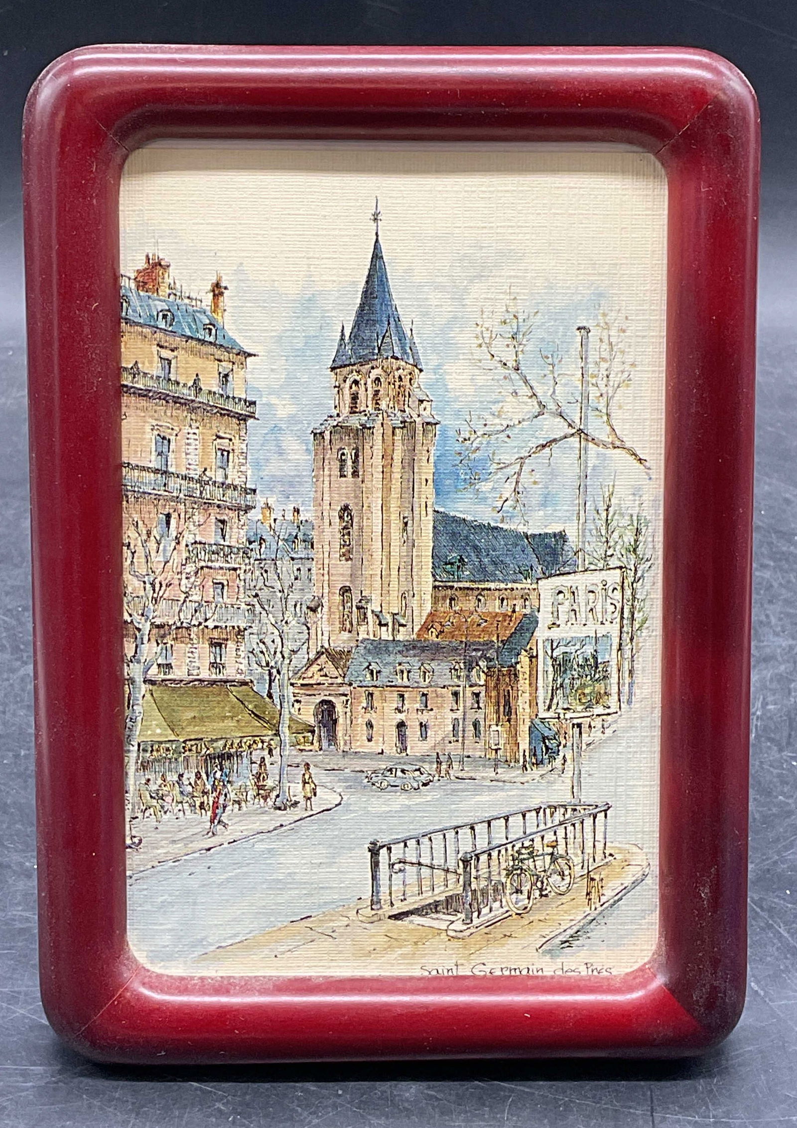 Framed Saint Germain Des Pres Print: Framed print on paper. Saint Germain des Pres. French street scene. Wood frame. Not examined out of frame. Frame measures approx 6.75 x 4.75 inches. Some wear consistent with exposure. Property of Upp