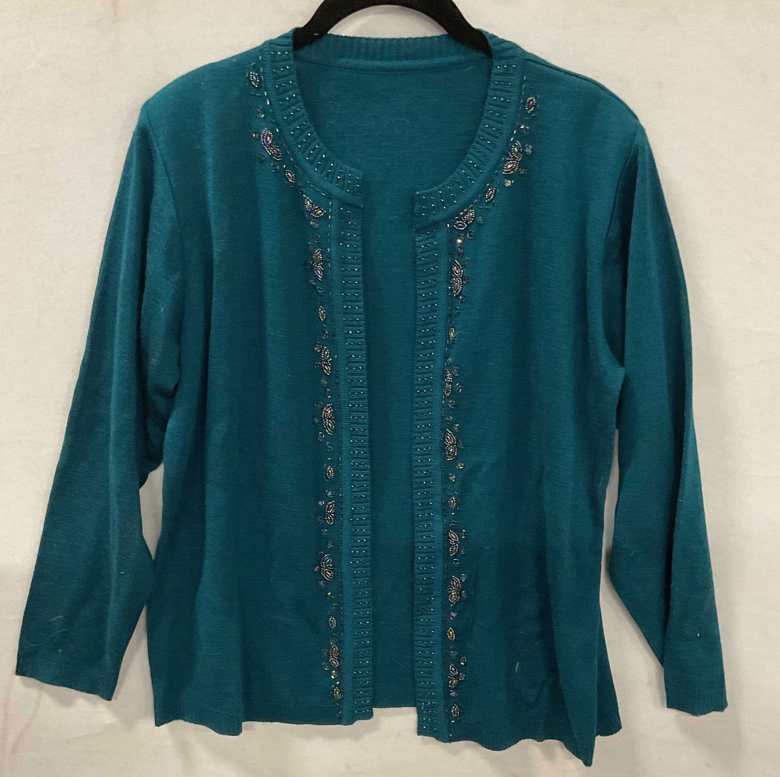 Teal Wool Blend Beaded Open Cardigan: Teal blue beaded open cardigan. Wool and acrylic blend. Measures approx 19 inches across chest. Some blemishes. Property of opera singers estate from the renowned and opulent Manhattan landmark The An