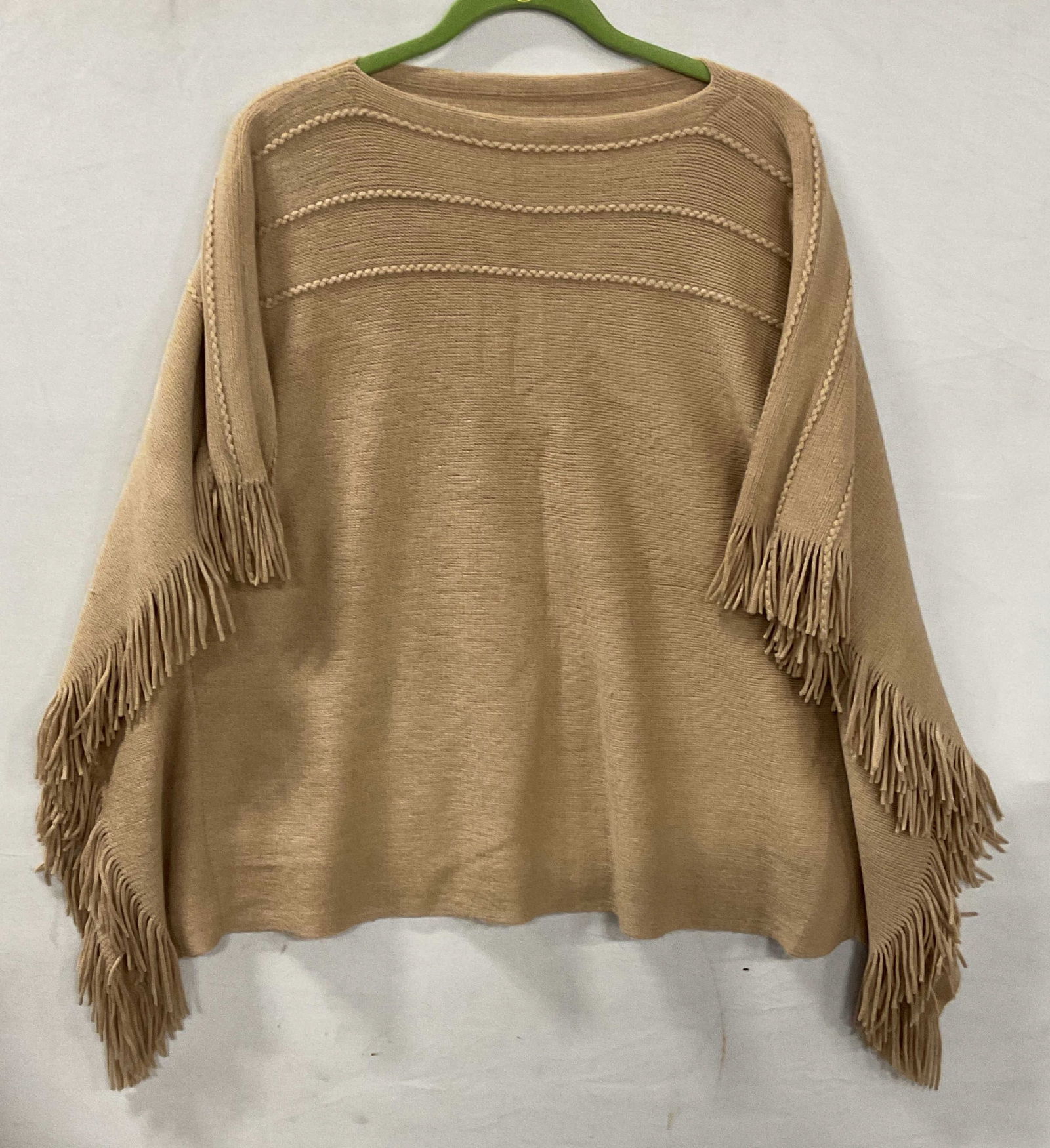Tan Knit Fringe Poncho Sweater: Tan knit fringe trim poncho sweater, feels like wool, possibly synthetic. Measures approx 23 inches across chest. Some pilling. Poncho, poncho sweater, tan poncho, tan sweater, fringe poncho, fringe s
