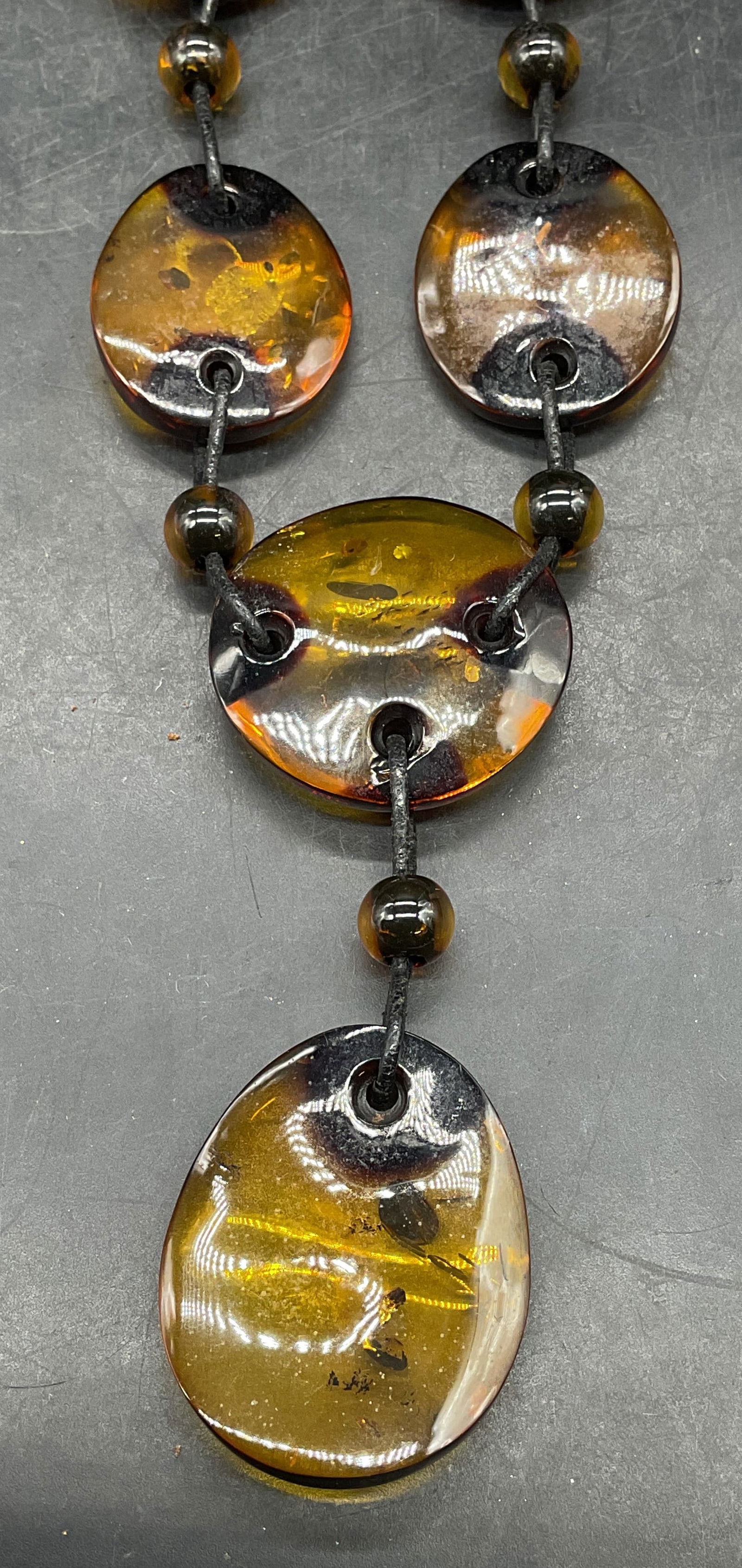 Vintage Amber Style Lucite Pendant Necklace: Vintage amber style lucite beaded pendant necklace on black leather cord. Drop length approx 7.5 inches. Jewelry, estate jewelry, costume jewelry, cocktail jewelry, fashion jewelry, accessories, fashi