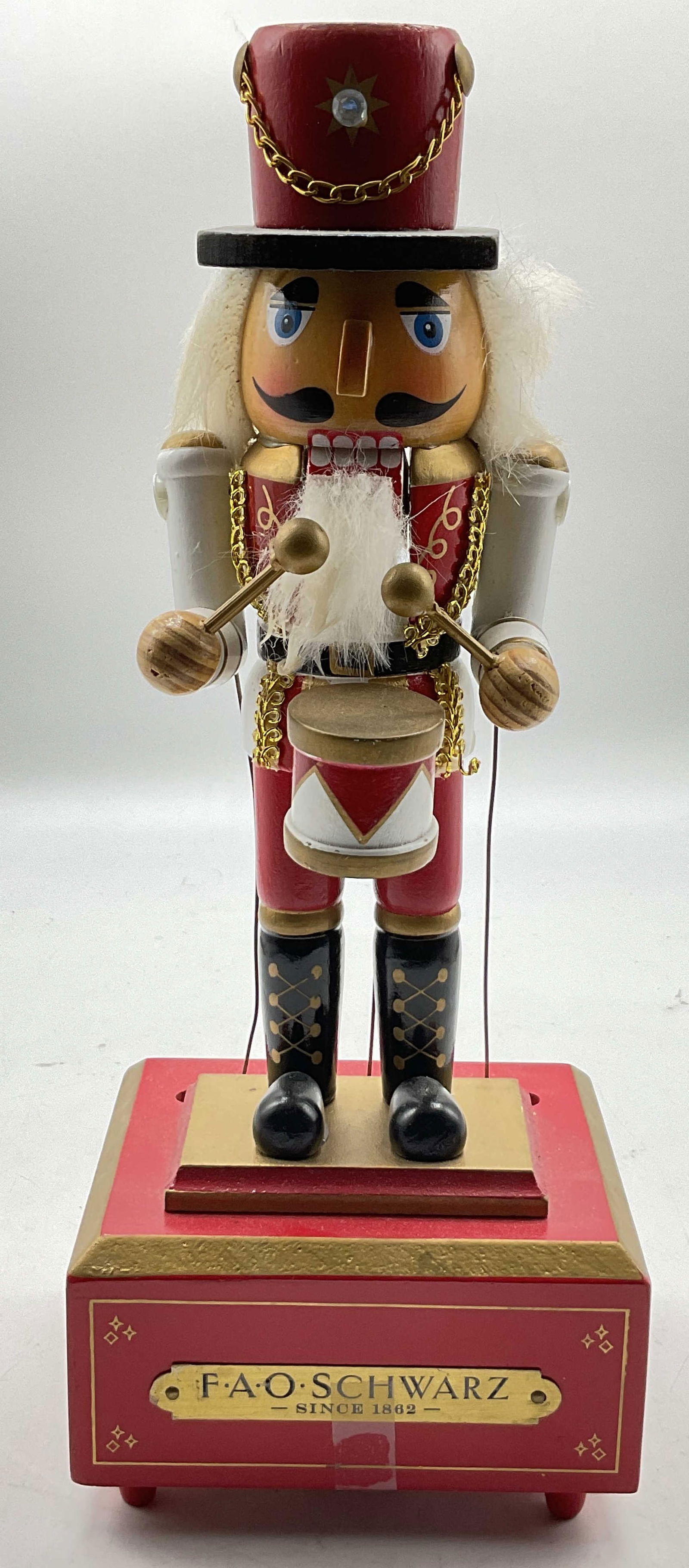 FAO Schwarz Musical Wooden Nutcracker Prince 12in: FAO Schwarz musical wooden nutcracker prince. Wooden nutcracker figure sits on top of a decorative music box. Hand painted features. Gilt decorations. Box reads FAO Schwarz Since 1862. Wind up mechani