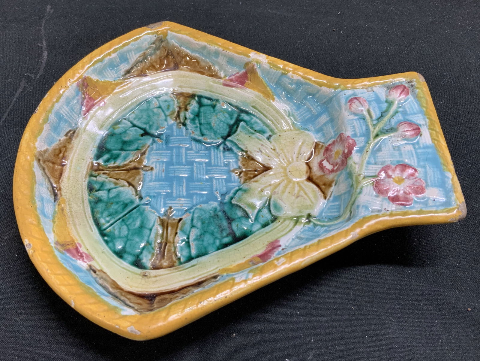 Sgnd Antq Majolica Pink Floral Ceramic Dish N.Y: Features raised floral & bow motifs in vibrant glazes of blue, yellow, green & pink. Center features a basket weave pattern. Surface wear consistent to age, use & exposure. Measurements: length 7in x