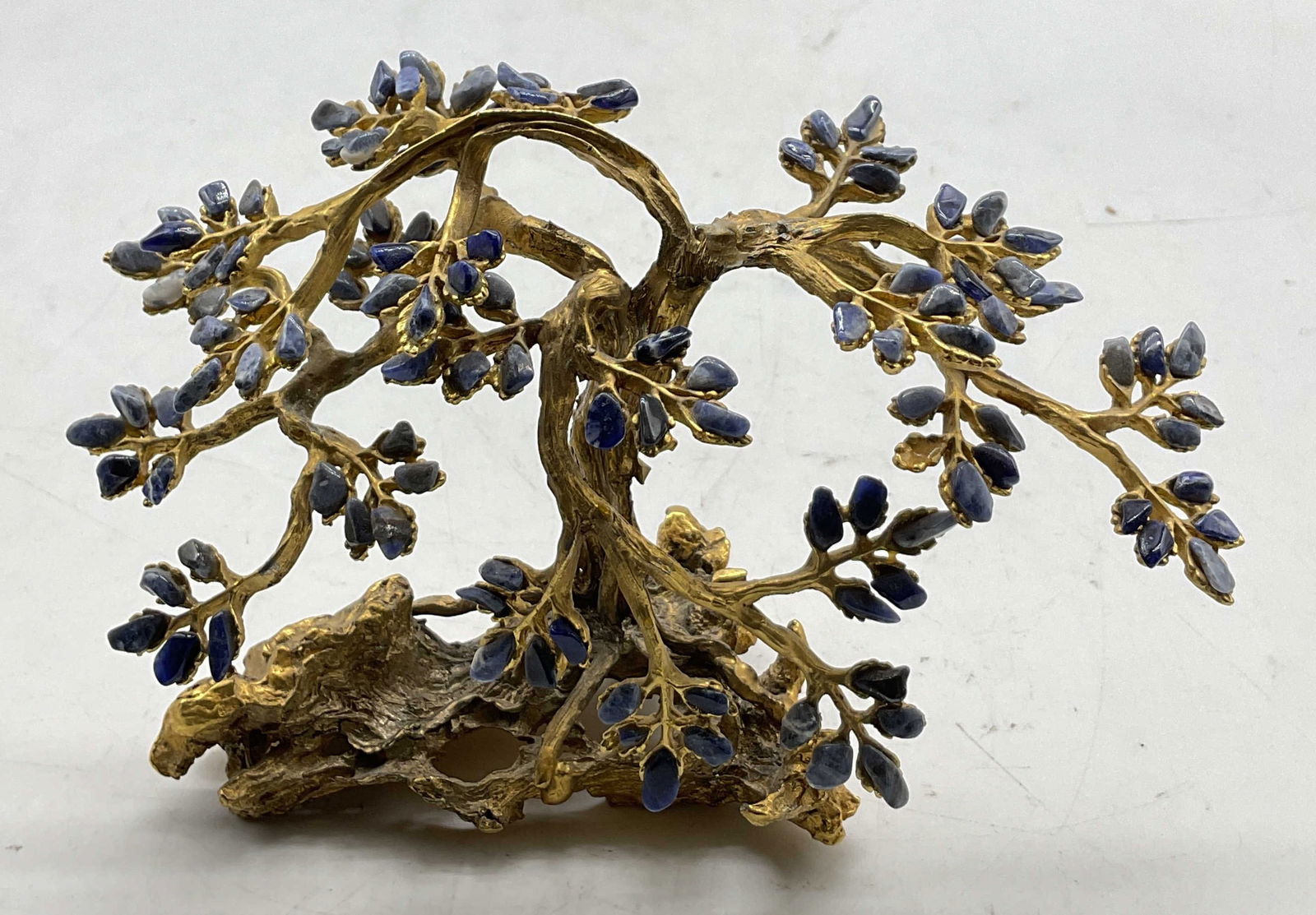 Vintage Swoboda Inc Brass Gemstone Tree Sculpture: Vintage Swoboda Inc brass gemstone tree sculpture. Marked Swoboda Inc on backside. Brass frame. Blue and purple gemstones as leaves. Detailed features and textures. Measures approx 4 x 2.5 x 4.5 inche
