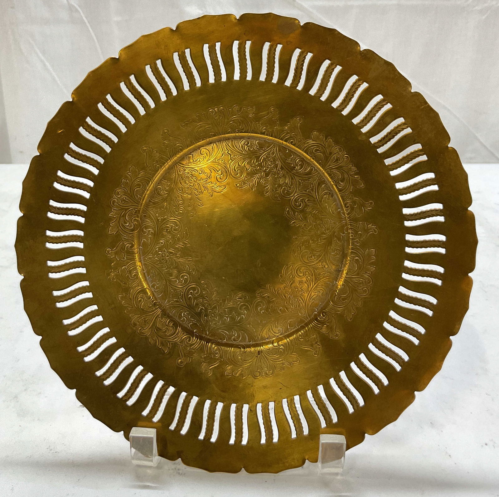 Vintage Etched Brass Decorative Plate: Vintage etched brass decorative plate. Ornate etched scroll and floral motifs. Slotted scalloped edge. Measures approx 10 inches in diameter. Surface wear consistent with exposure. Plate, decorative p