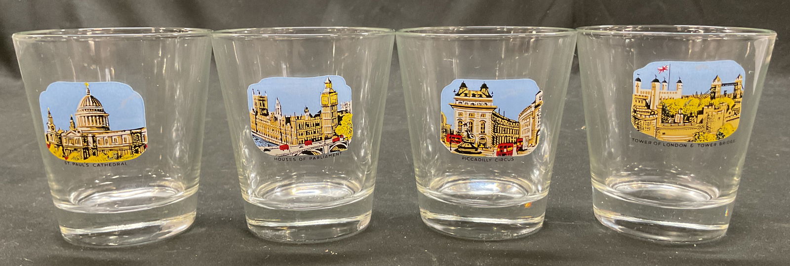 Lot 4 London Souvenir Shot Glasses France: Lot of 4 London souvenir shot glasses. Marked France on underside. Designs include St. Pauls Cathedral, Houses Of Parliament, Piccadilly Circus, and Tower Of London & Tower Bridge. Measures ht approx