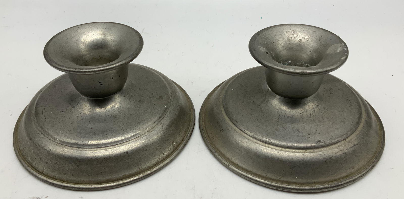 Pair Vtg Woodbury Pewter Candlestick Holders: Lot includes, a pair of vintage Woodbury pewter candlestick holders. Round base. Signed & marked on underside. Reads, WOODBURY PEWTERERS. Surface wear consistent to age, use & exposure. Measurements: