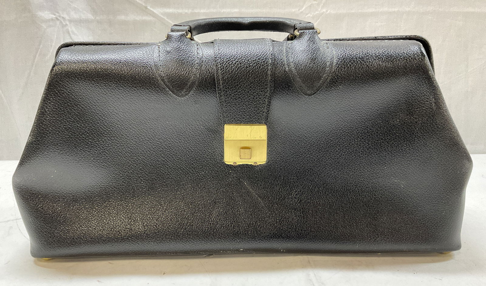 Schell Black Leather Gladstone Bag USA: Schell black leather gladstone bag. Marked on underside, reads Schell St. Petersburg, FL Made In USA Genuine Leather. Gold toned accents. Opens to compartments. Attached handles. Measures approx 16 x
