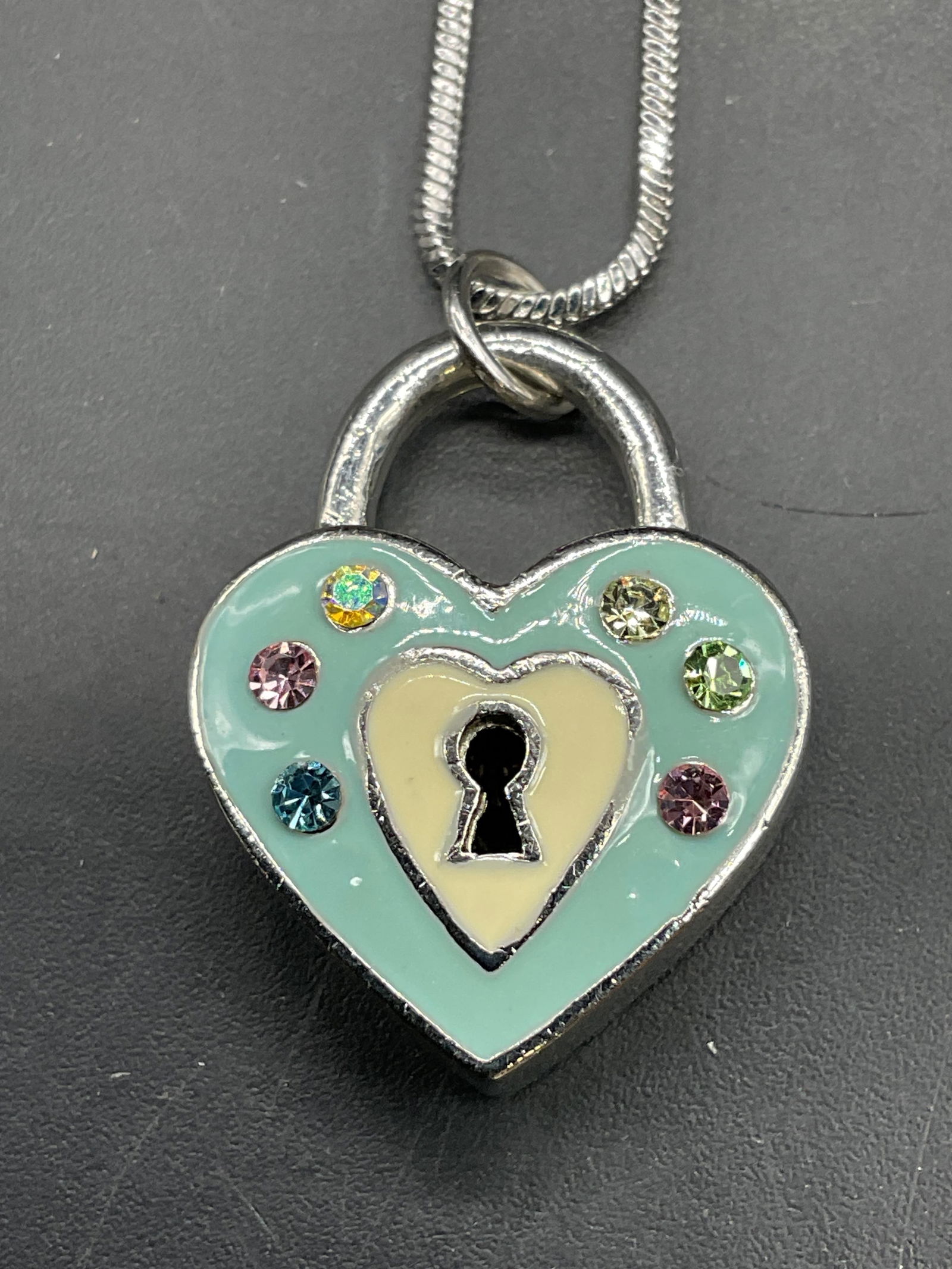 Silver Tone Enamel Heart Pendant Necklace: Silver tone necklace its enamel and crystal heart lock motif pendant. Drop length approx 7.25 inches. Some scratching. Jewelry, estate jewelry, costume jewelry, cocktail jewelry, fashion jewelry, acce