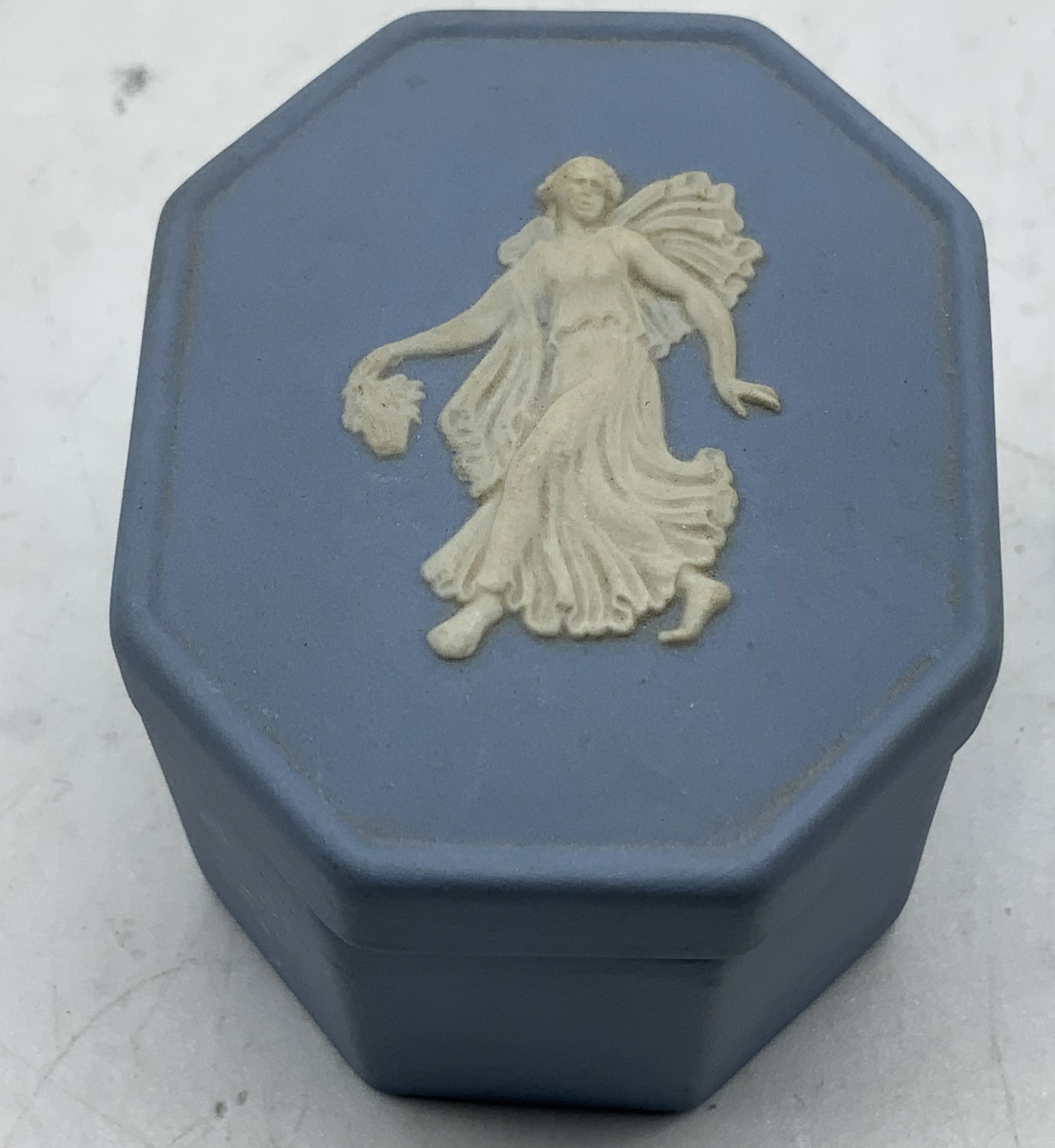 Wedgwood Blue Jasperware Trinket Box ENGLAND: Wedgwood blue jasperware trinket box features a white relief classical fig on lid. Signed & marked on underside. Reads, WEDGWOOD MADE IN ENGLAND. Surface wear consistent to age, use & exposure. Measur