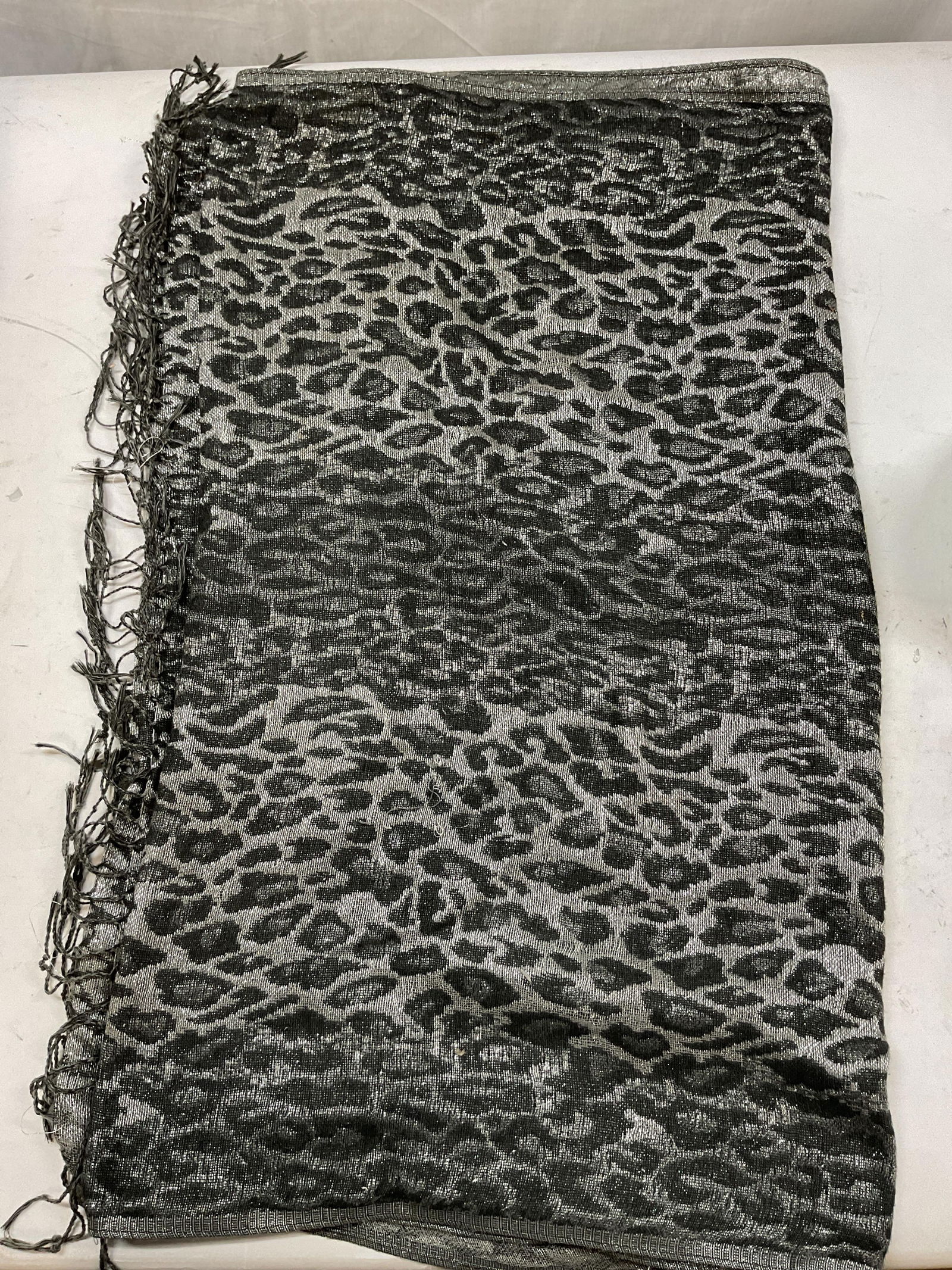 Vintage Leopard Wool Fringed Scarf: Vintage leopard wool fringed scarf. Feels like wool. Grey silver toned metallic leopard print. Grey fringed trim. Measures approx 25 x 63 inches. Some pull to stitching. Property of Upper East