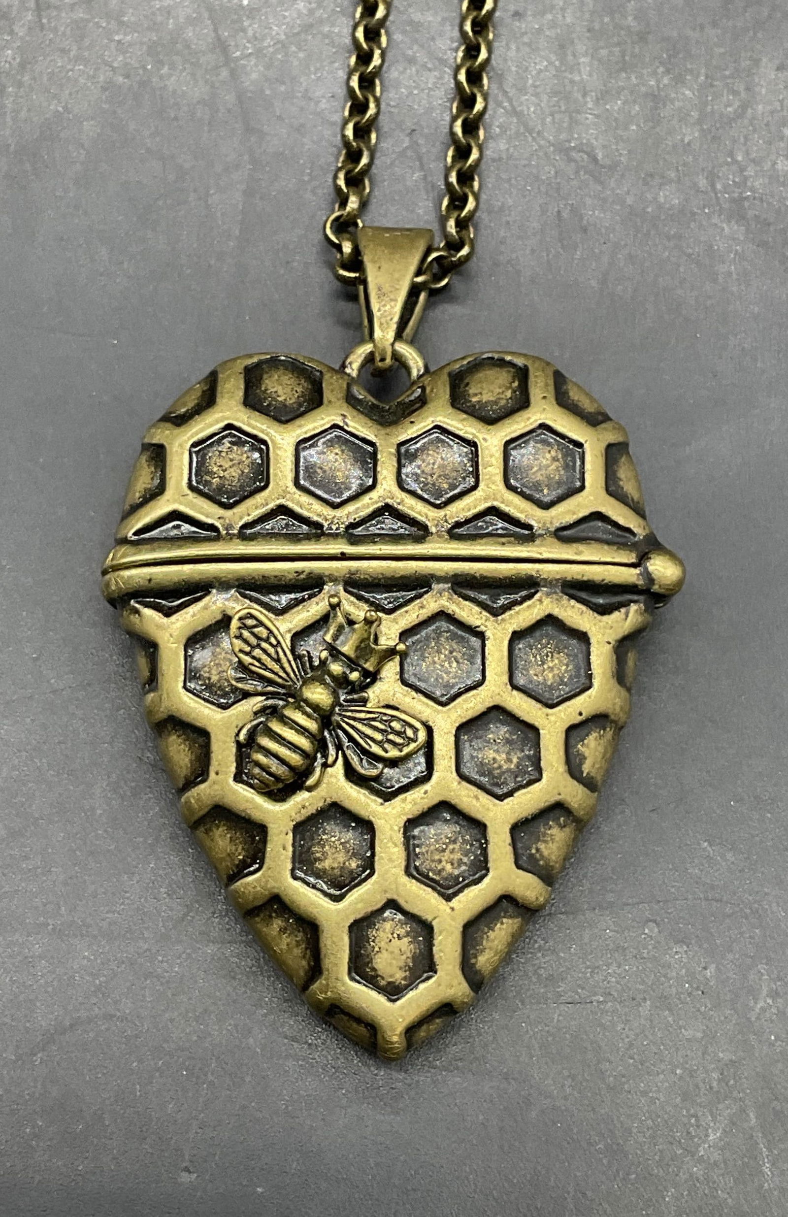 Gold Tone Heart Bee Locket Necklace: Gold tone pendant necklace with heart honeycomb and bee motif locket pendant. Drop length approx 15.5 inches. Pendant approx 1.75 x 1.5 inches. Some scratching. Jewelry, estate jewelry, costume
