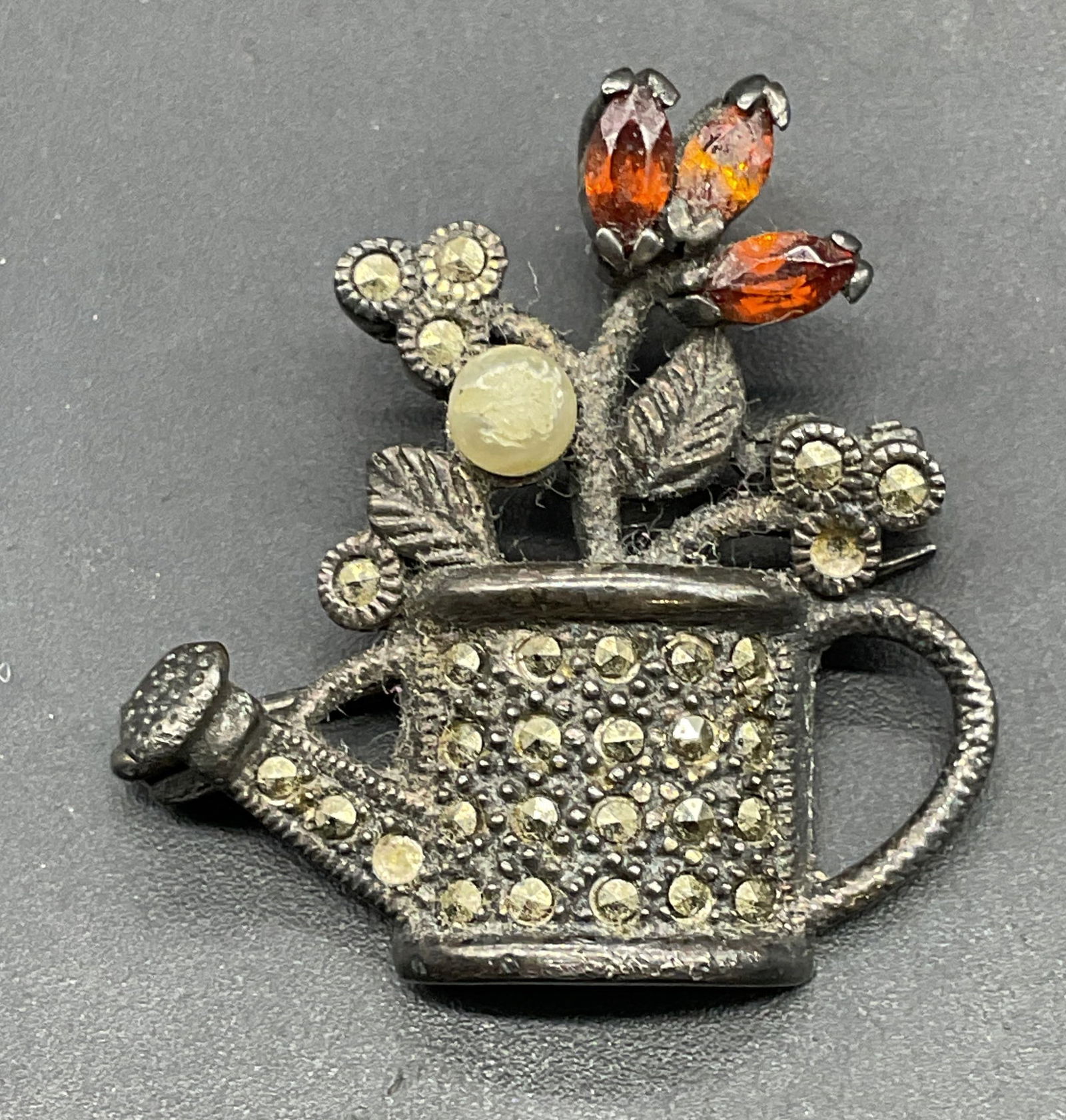 Vtg Sterling Silver Crystal Watering Can Brooch: Vintage sterling silver, marcasite, crystal, and faux pearl watering can brooch. Marked sterling. Measures approx. 1 x 1 inches. Total weight 6.8 grams. Clasp needs repair. Some scratching and