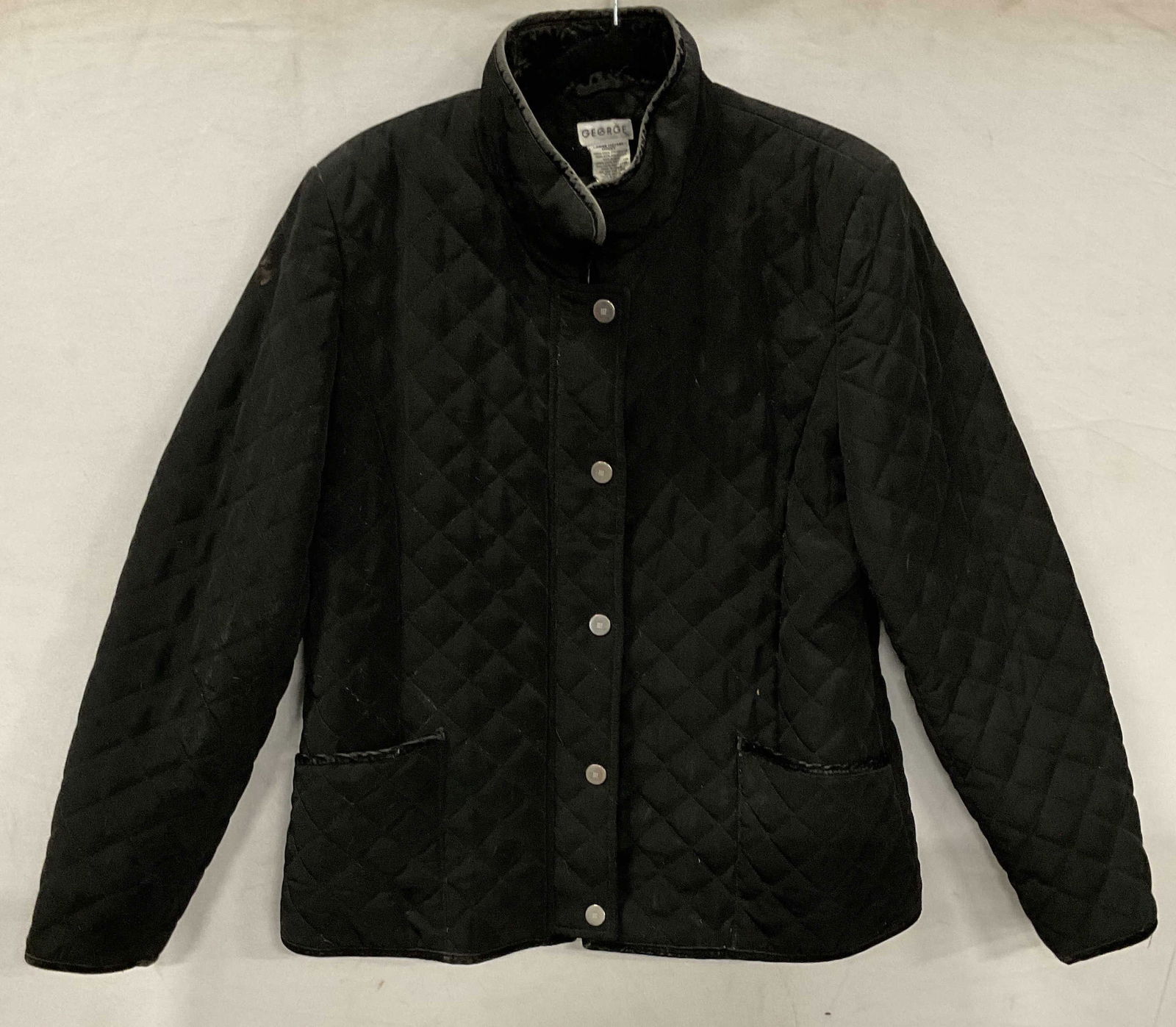 George Quilted Black Velvet Trim Coat: George black quilted coat with velvet trim. Size large (12/14). Polyester and polyester nylon blend. Wear including blemishes and losses to trim. Property of opera singers estate from the renowned