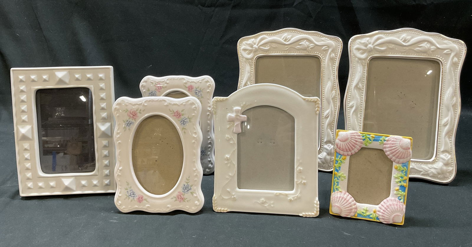 Lot 7 Assort Porc & Ceramic Frames Jonathan Adler+: Lot of 7 assorted porcelain and ceramic picture frames. Brands include Jonathan Adler, Terragrafics, Burnes, and Russ Berrie. Hand painted features. Scalloped and gilt edges. Floral and shell motifs.