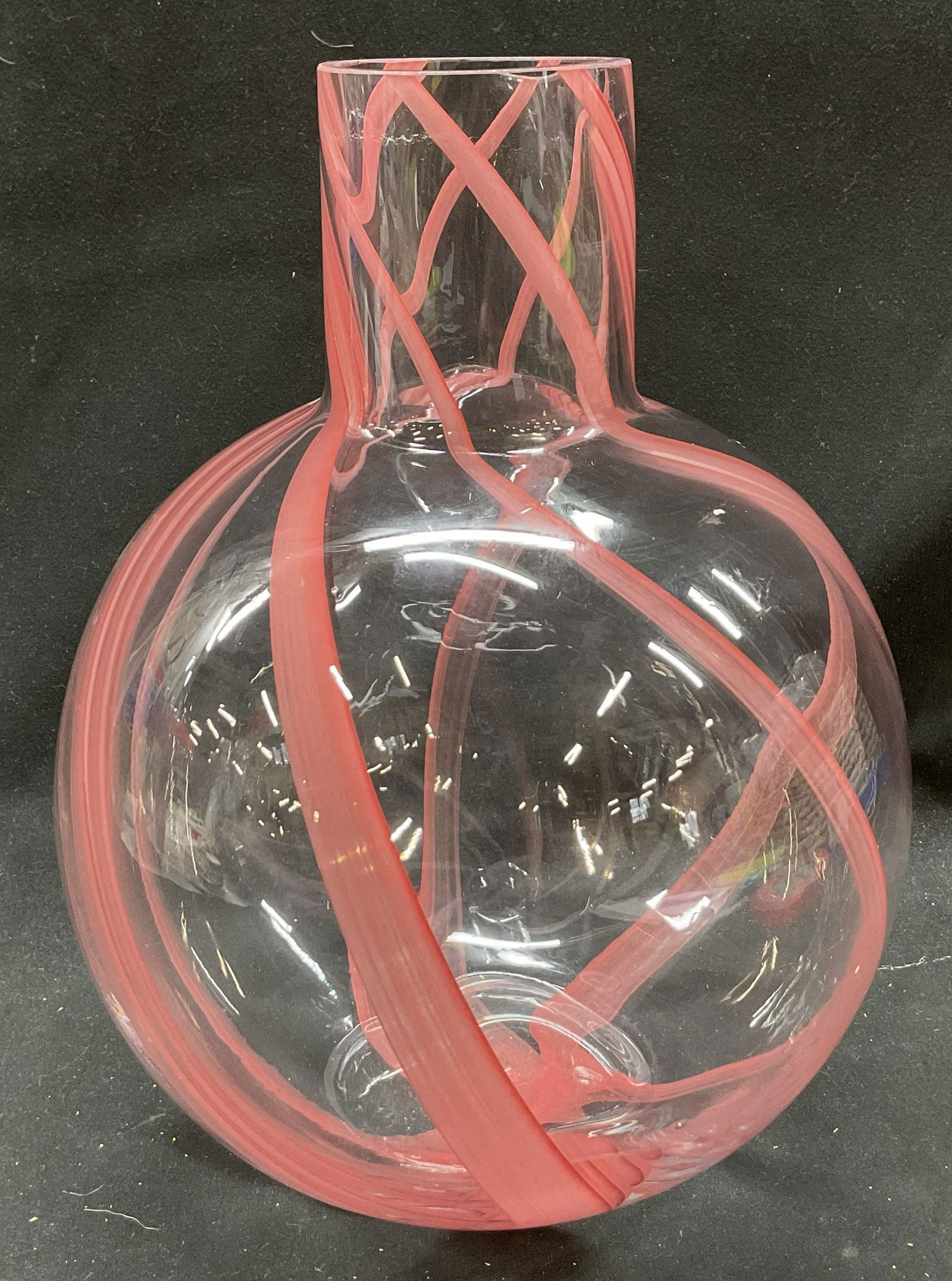 Hand Blown Art Glass Red Striped Vase: Hand blown art glass red striped vase. Round spherical body and tall narrow neck. Swirling criss crossed red stripes throughout. Measures ht approx 10 inches diam approx 9 inches. Some scratching