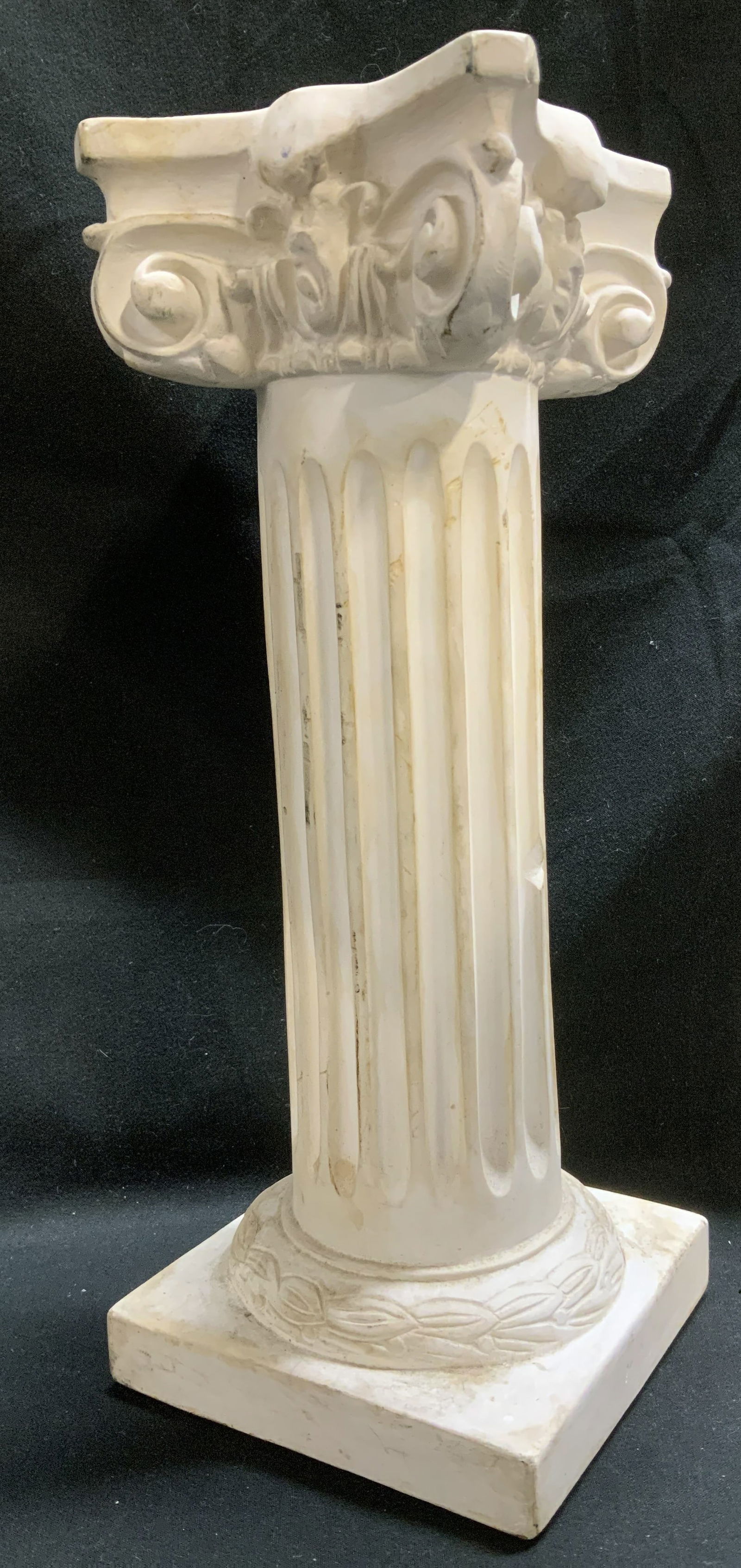 White Classical Style Column Pedestal: Column pedestal featuring a fluted shaft & stylized scrollwork style. Square base & etched detailing. Appears to be possible plaster material. Property of Upper East Side French stage and screen actor