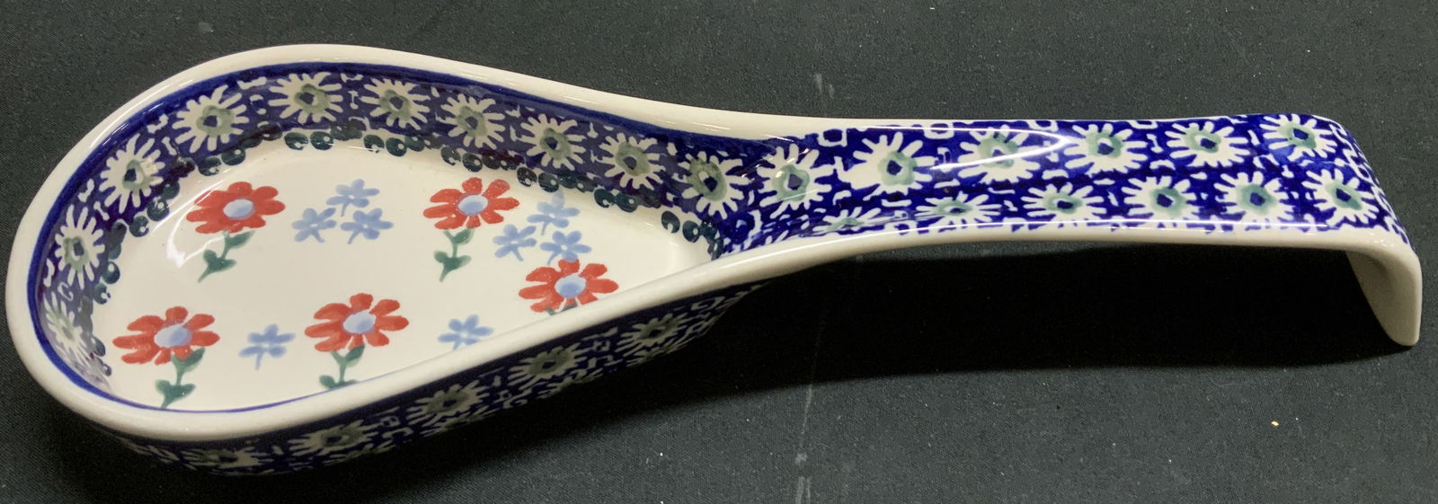 Boleslawiec Hand Painted Spoon Rest POLAND: Boleslawiec spoon rest features hand painted red floral & geometric accents. Ceramic material. Signed & marked on underside. Reads, BOLESLAWIEC HAND MADE IN POLAND. Surface wear consistent to age, use