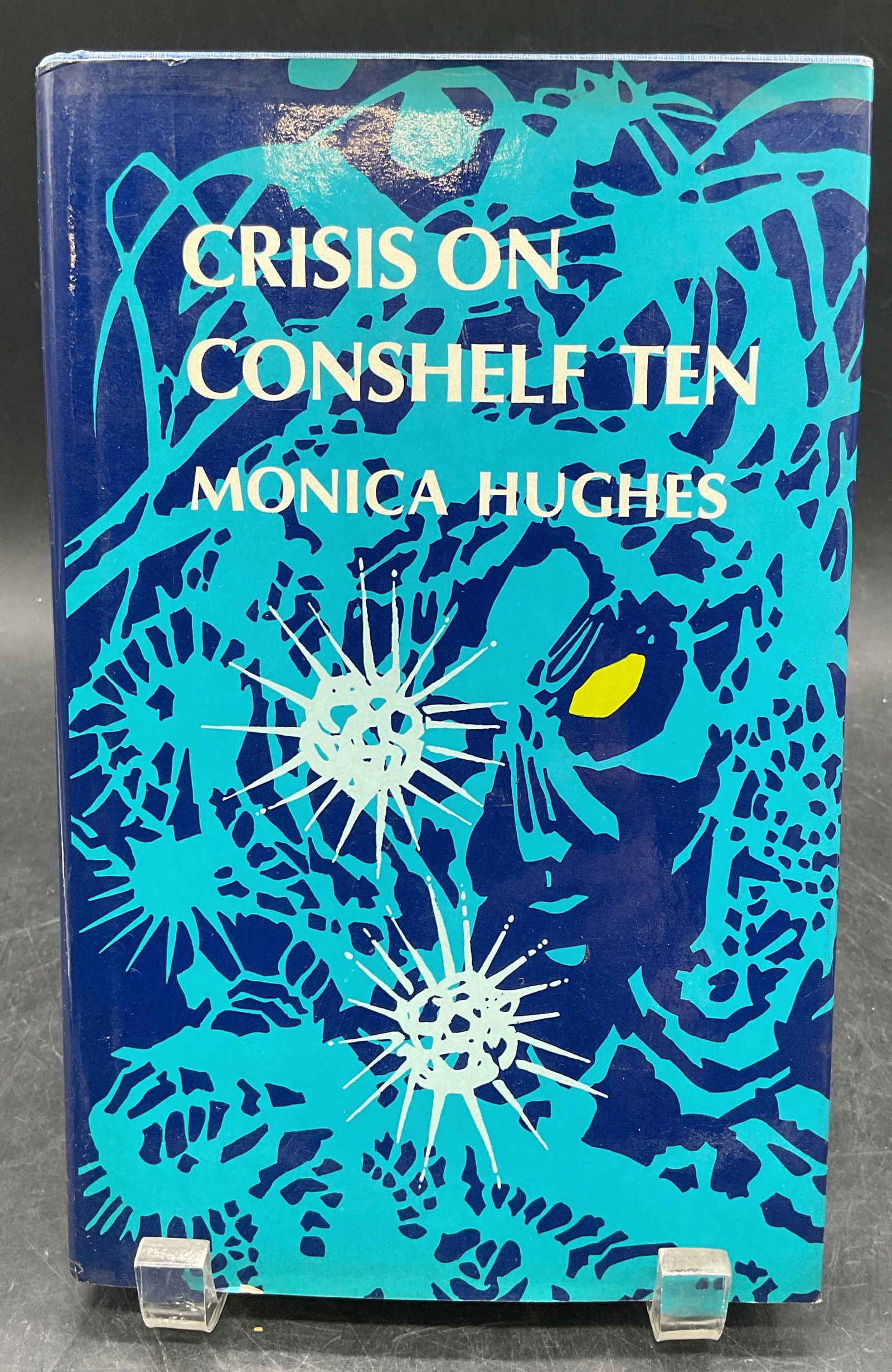 1977 Crisis on Conshelf Ten, Hughes, 1st Edt: Hardcover first American edition copy of Crisis On Conshelf Ten by Monica Hughes. Atheneum, 1977. Measures approx. 9 x 5.75 inches. wear to cover, pages, and binding consistent with exposure. Book, co