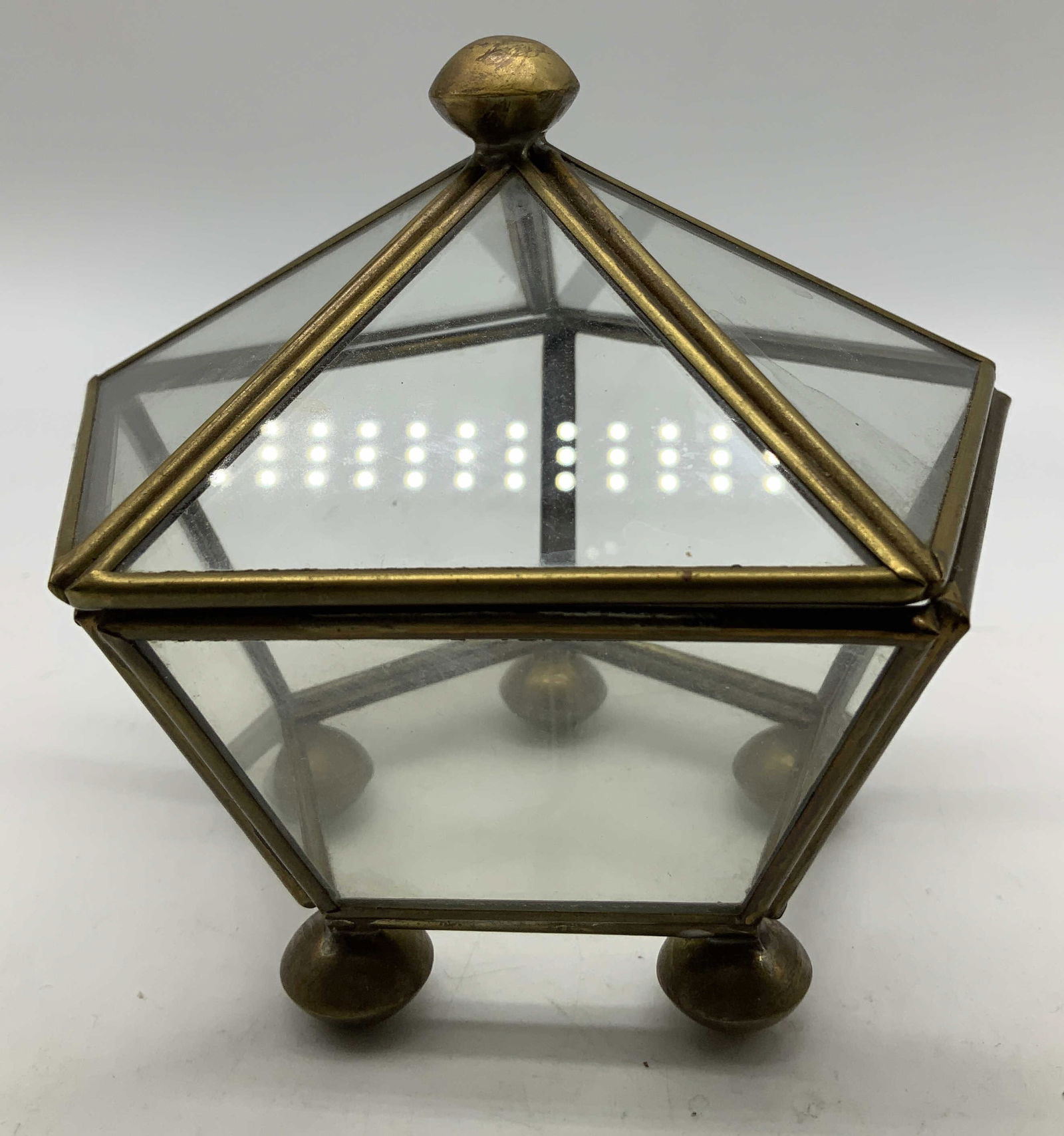 Vtg Brass & Glass Pentagon Shaped Box: Vintage brass & glass box shaped like a pentagon. Stands on 5 feet. Surface wear consistent to age, use & exposure. Measurements: Length 4.5in x width 4.5in x height 4.5in. Vintage brass & glass penta