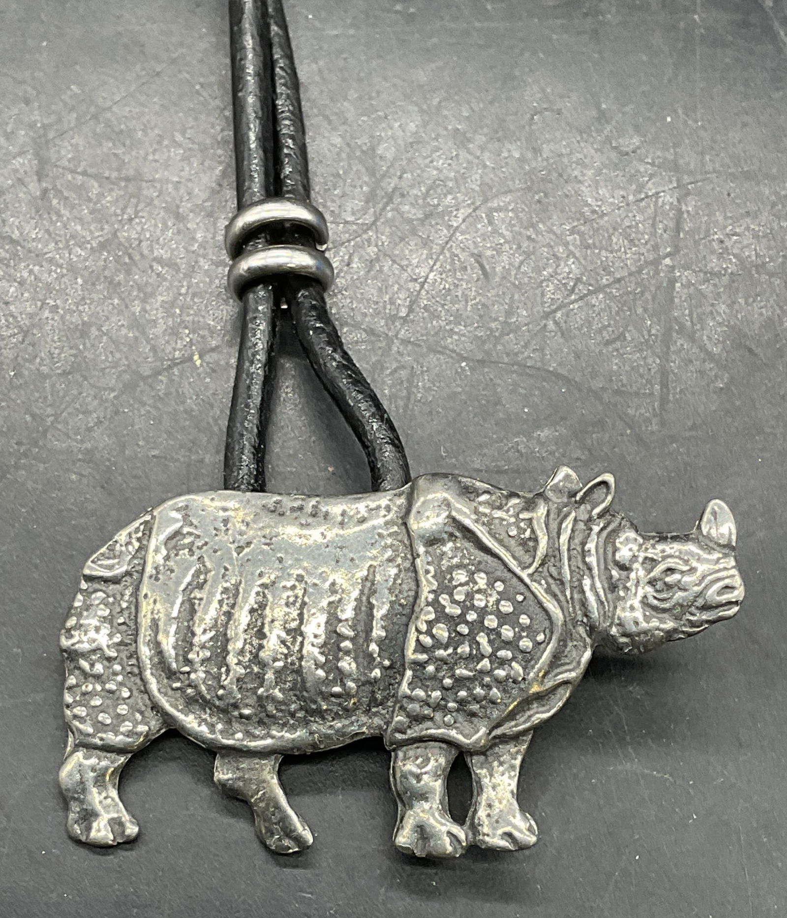 Silver Tone Rhino Pendant Necklace: Silver tone rhino pendant necklace with black leather cord. Drop length approx 8.5 inches. Some scratching. Jewelry, estate jewelry, costume jewelry, cocktail jewelry, fashion jewelry,