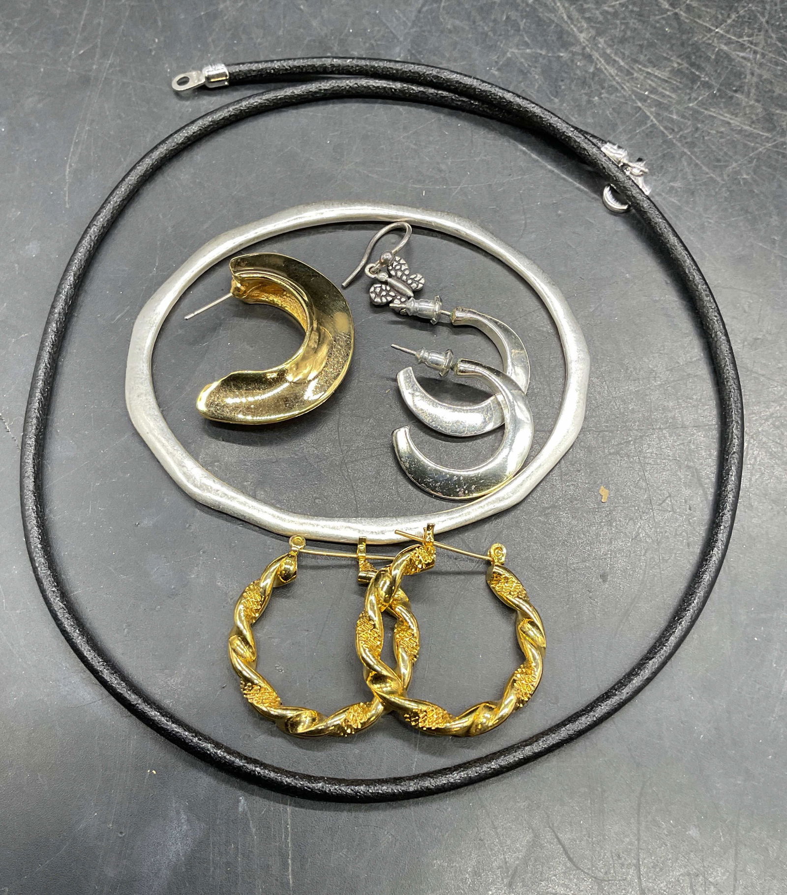 Lot 6 Silver & Gold Tone Earrings +: Lot of 6 jewelry pieces. Gold tone twisted hoop earrings, single gold tone half hoop earring, silver tone half hoop earrings, single silver tone butterfly earring, silver tone modernist bangle