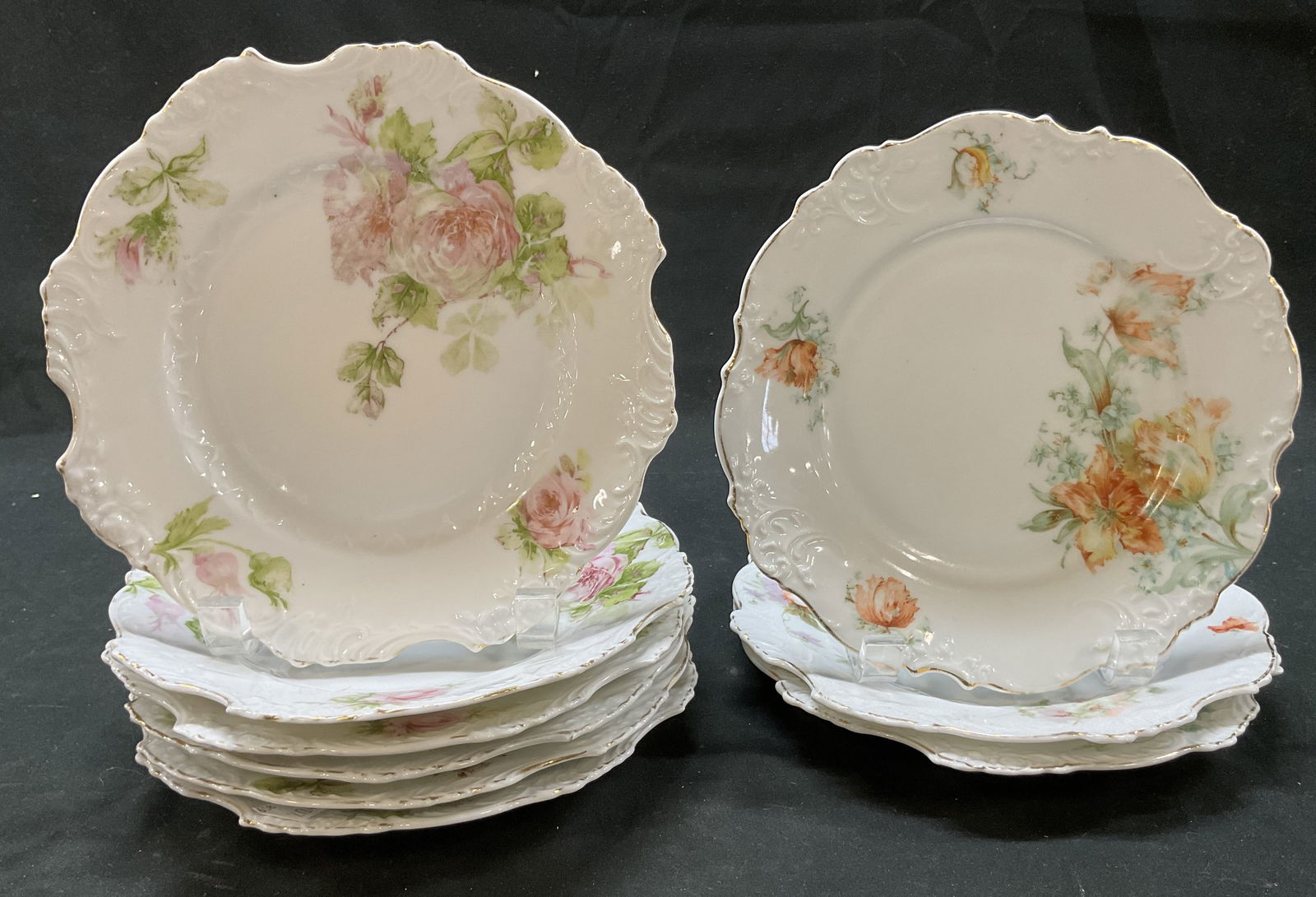 Lot 9 Hermann Ohme Porcelain Plates Germany+: Lot of 9 Hermann Ohme porcelain plates. Signed Germany and Prussia on underside. Scalloped gilt decorated rim. Hand painted floral motifs in varying colors. Measures approx 8 inches in diameter. Surfa