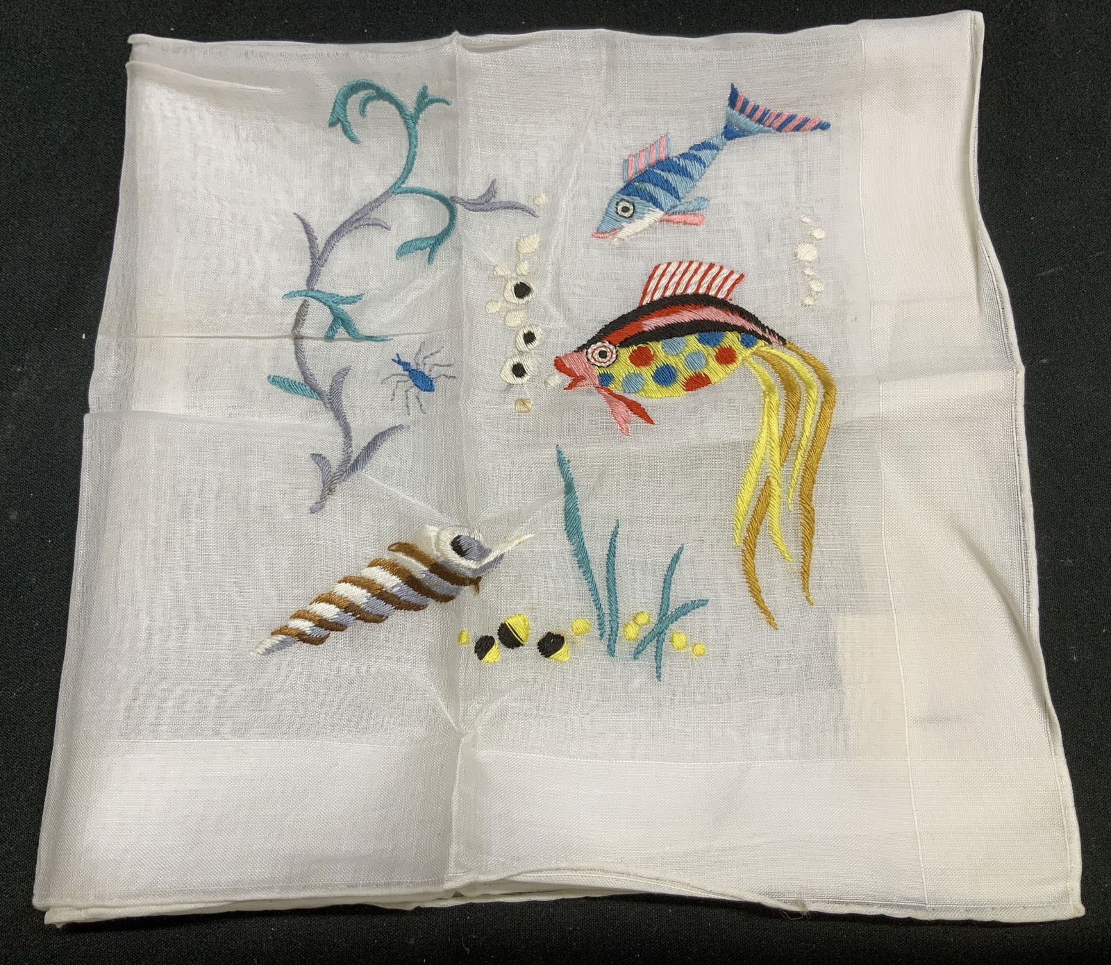 Celebrities Embroidered Fish Handkerchief SWITZ: Celebrities handkerchief features embroidered fish, shell & seaweed motifs. Shades of blue, pink, yellow, red, pink & more. Cotton material. Comes with B. Altman & Co tag & cardboard. Surface