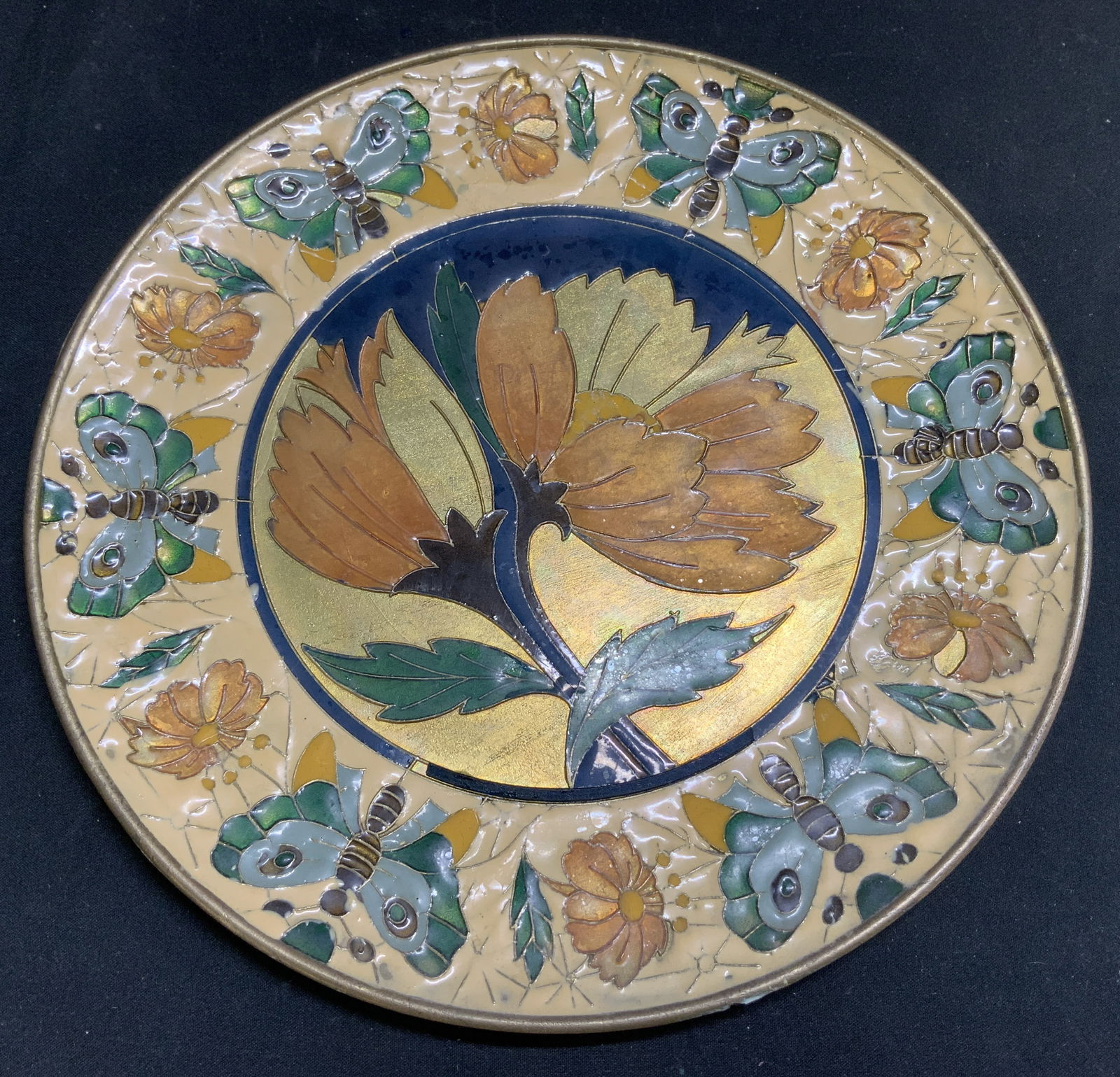 Vtg Hand Painted Floral Brass Deco Plate: Vintage decorative plate features hand painted floral & Butterly motifs. Brass material. Shades of green, orange, blue, yellow. Property of opera singers estate from the renowned & opulent