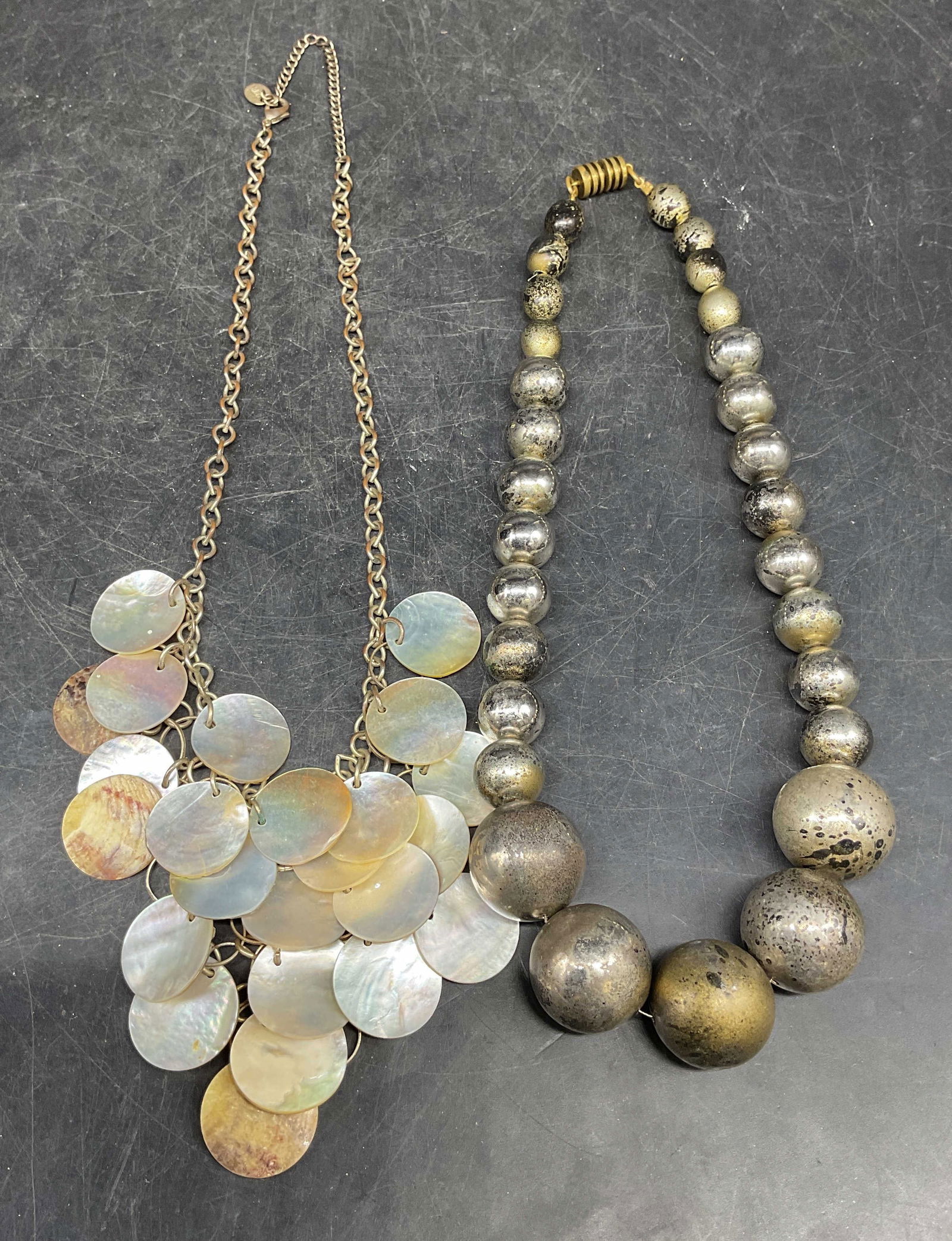 2 Claires Faux MOP Necklace, Silver Tn Necklace: Lot of 2 jewelry pieces. Signed Claires silver tone faux mother of pearl disc necklace. Drop length approx 9 inches. Vintage silver tone beaded necklace drop length approx 8 inches. Some scratching an