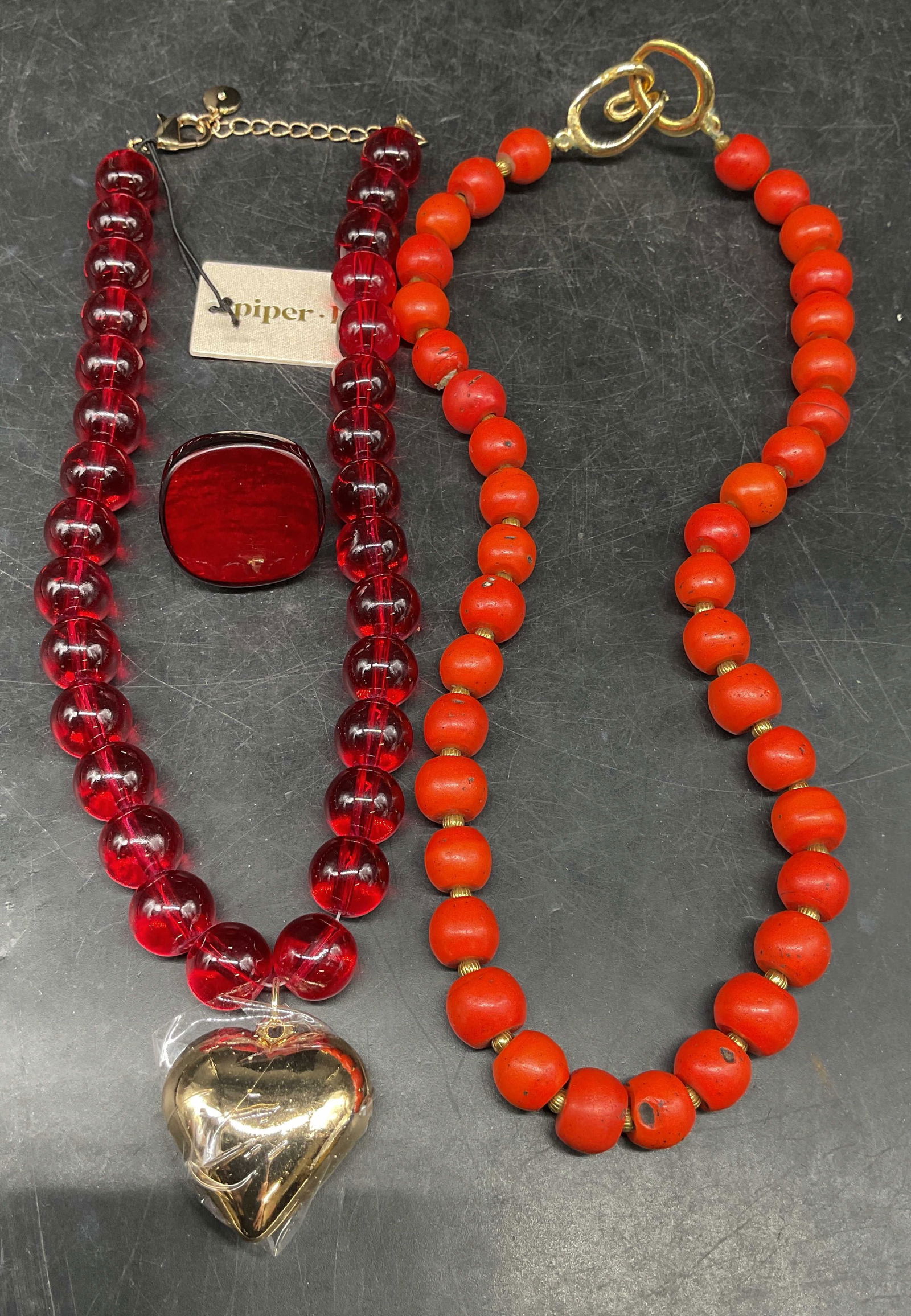 Lot 3 Piper K Red Heart Necklace NWT + More: Lot of 3 jewelry pieces. Piper K red glass beaded necklace with gold tone heart pendant. New with tag. Drop length approx 9 inches. Faux red coral beaded necklace. Drop length approx 9 inches. Red luc