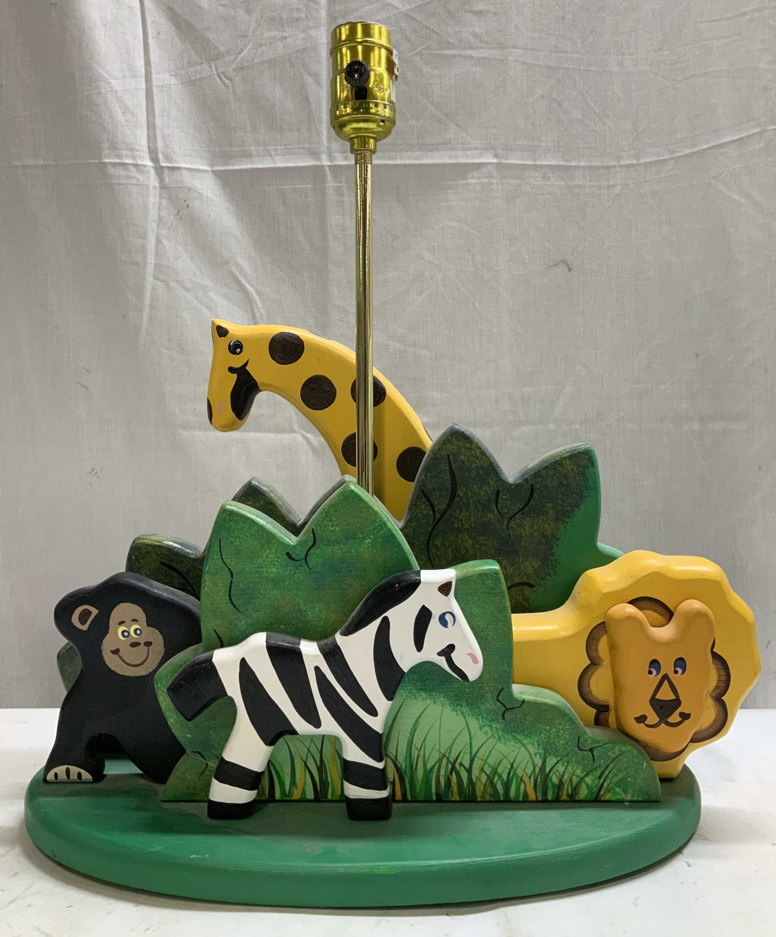 Vtg Hand Painted Wooden Safari Table Lamp: Vintage table lamp features several hand painted animals, including a lion, zebra, monkey & giraffe. Green toned base. Signed & marked on underside. Reads, INMON ENT. NIXA MO. 65714. Surface wear cons