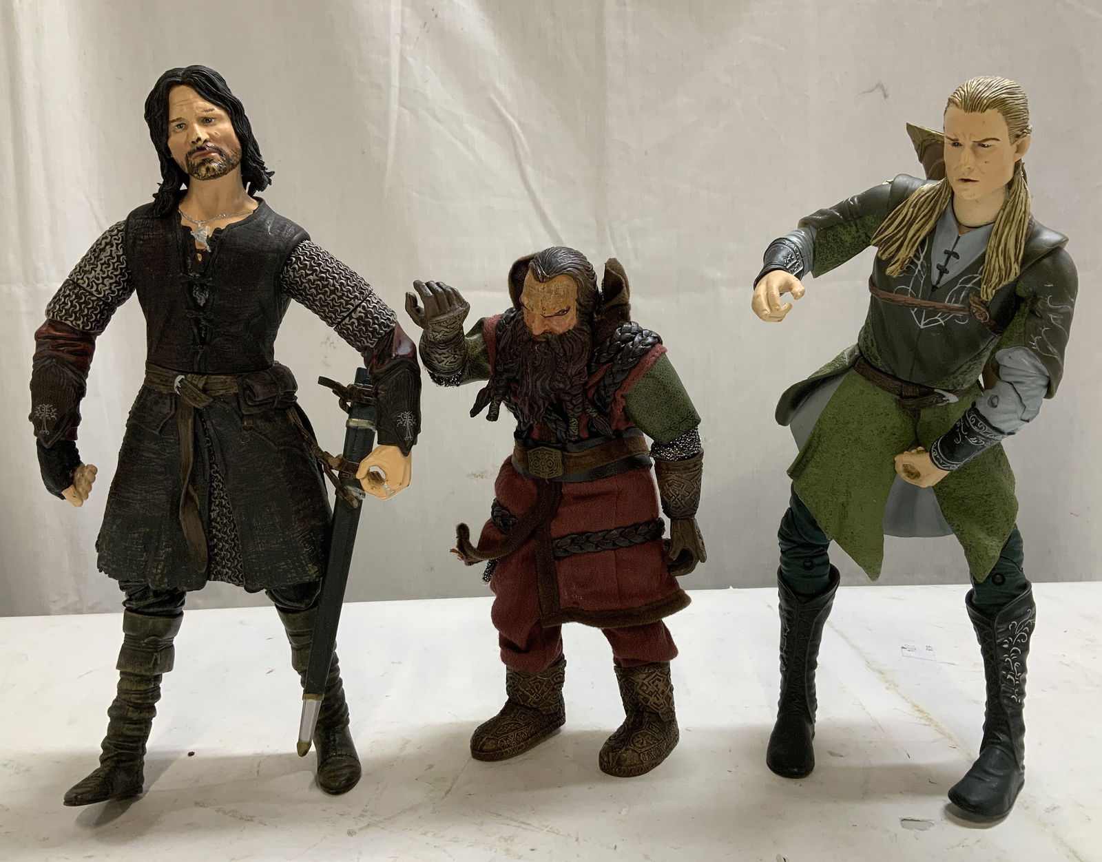 Lt3 The Lord of the Rings 2000 & 2003 Action Figs: Lot includes, 3 action figures from The Lord of the Rings, including Legolas, Gimli, & Aragorn. Figs vary in size & have intricate detailing. Comes with accessories. Signed & marked on underside.