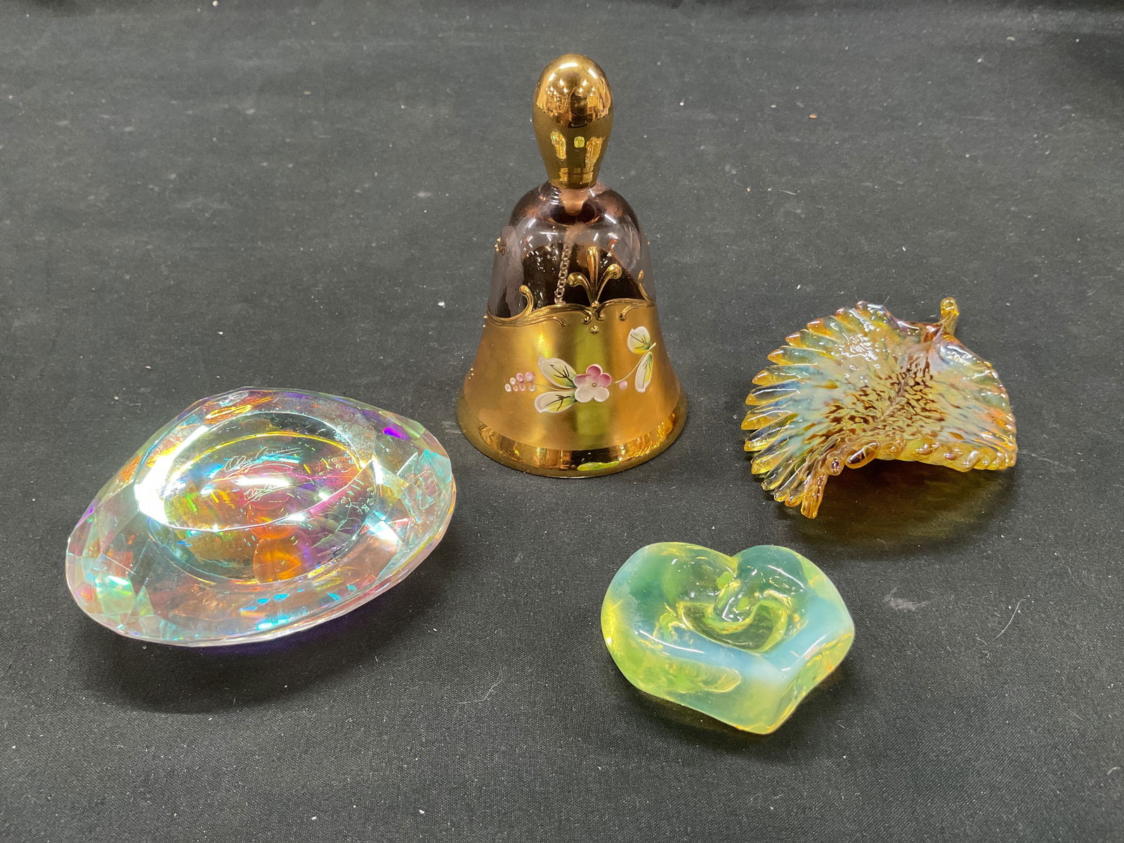 Lot 4 Vintage Iridescent Glass Decorative Objects: Lot of 4 vintage iridescent glass trinkets. Includes a clam shell with decorative pearl (signed illegibly), leaf, bell, and heart shape. Iridescent shine. Gilt decoration with hand painted floral moti