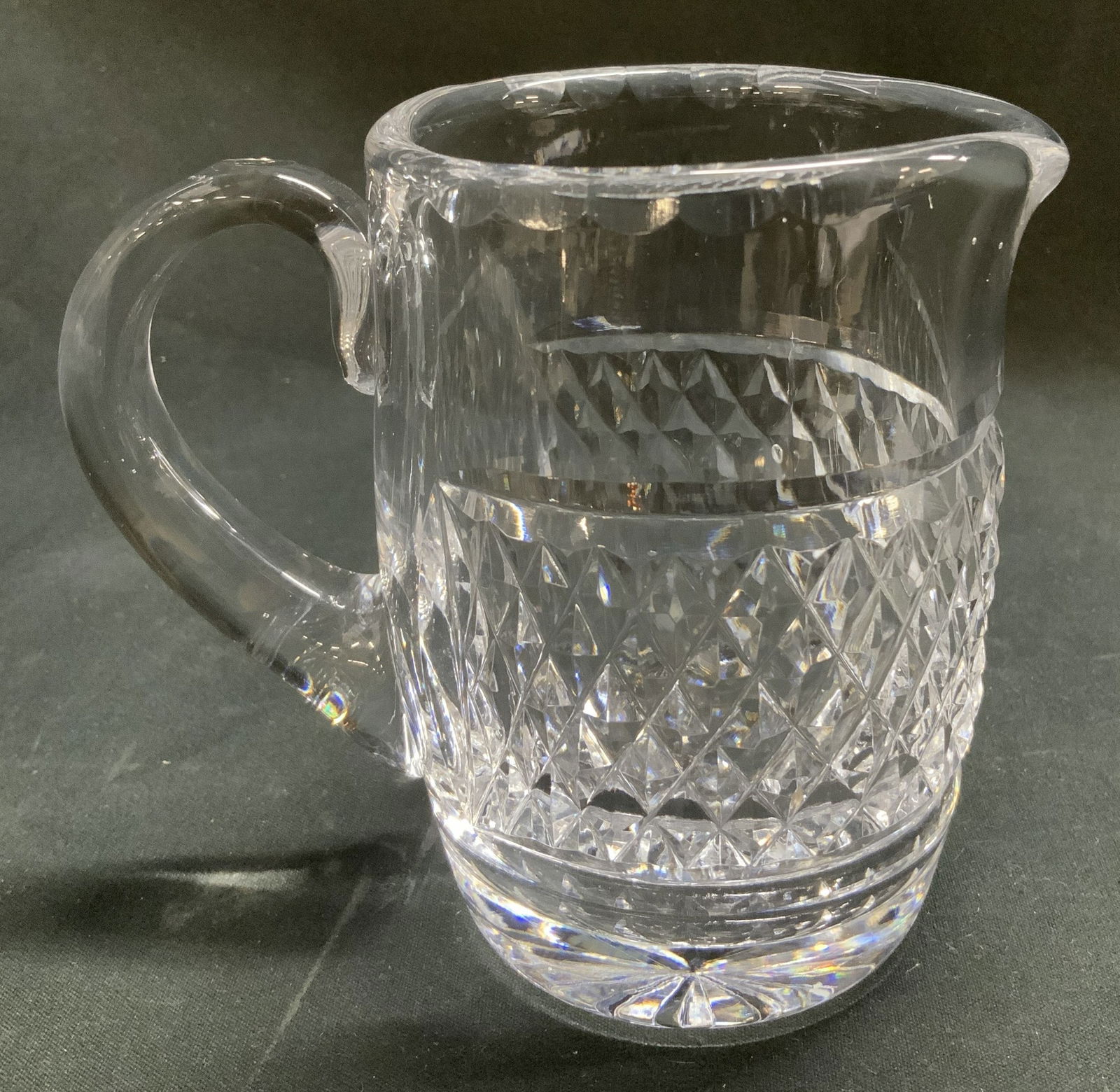 Waterford Clear Crystal Creamer: Waterford creamer features diamond & wedge cuts. Clear crystal material. Signed & marked. Reads, WATERFORD. Surface wear consistent to age, use & exposure. Measurements: length 4.7in x width 3in x