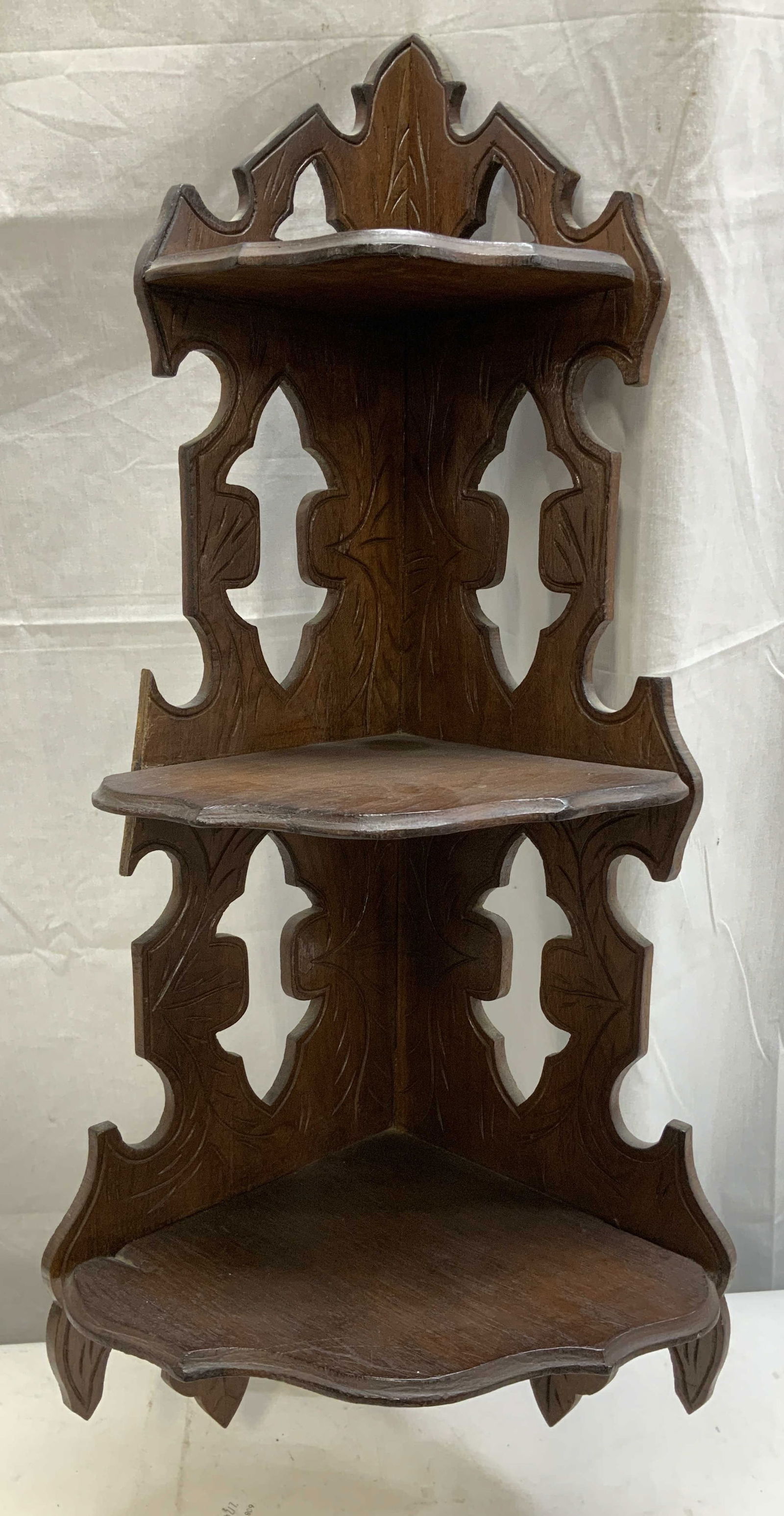 Vtg Wooden Carved Hanging Corner Shelf: Vintage hanging corner shelf features carved leaf detailing. Brown toned & features 3 tiers. Surface wear consistent to age, use & exposure. Measurements: height 30in x width 13in. Vintage wooden