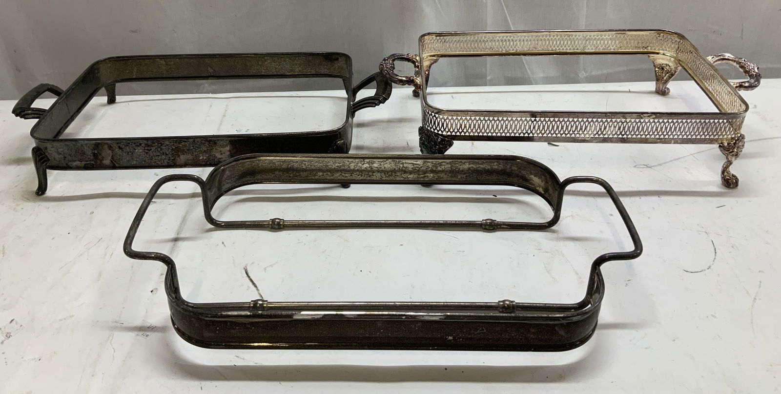 Lot 3 Vtg Silver Plated Dish Holders: Lot includes, 3 silver plated dish holders featuring a rectangular shape. 2 dish holders feature ornate handles. Surface wear consistent to age, use & exposure. Measurements: length 18.1in x width 9.5
