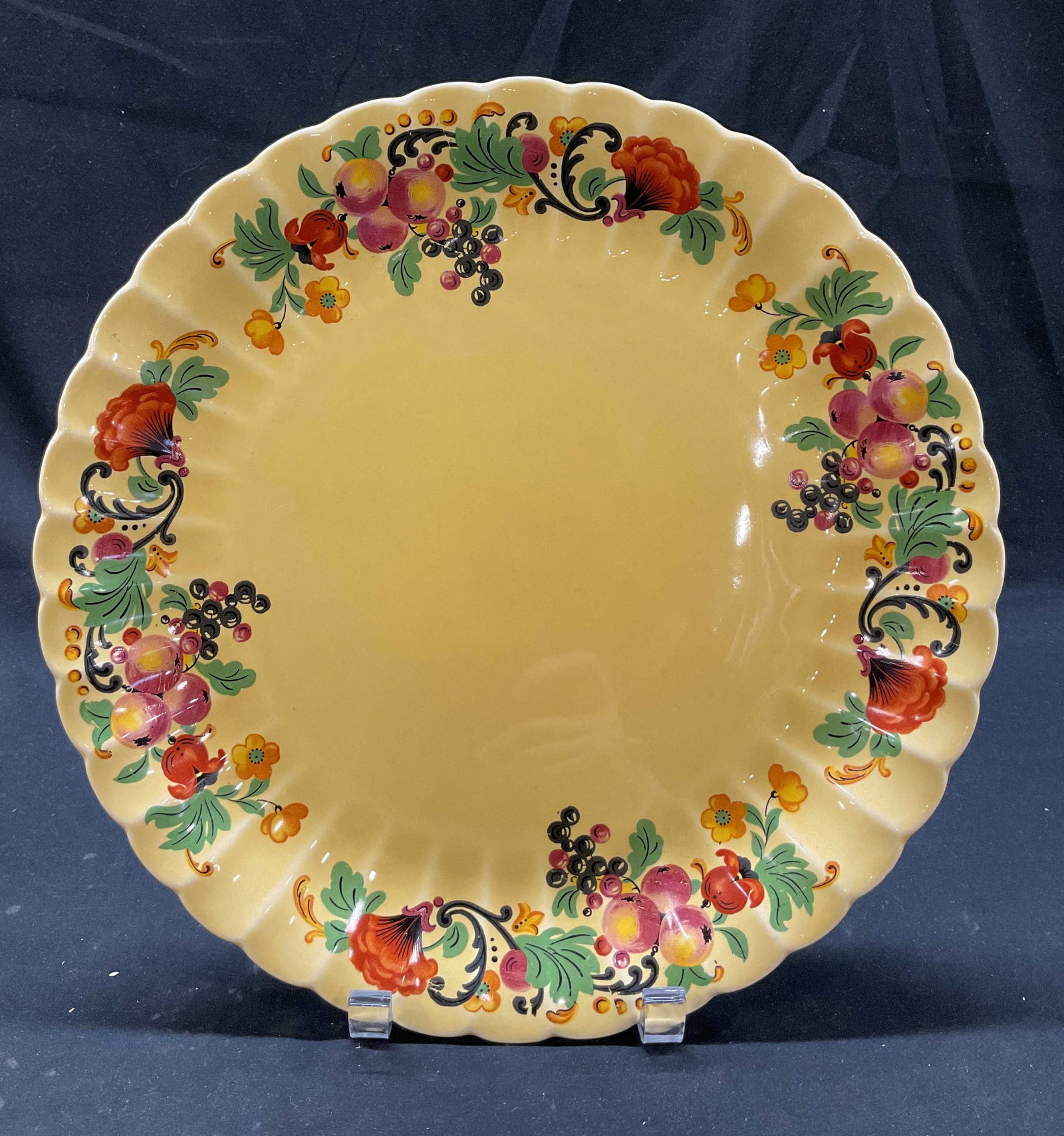 Trojan By Sebring Ceramic Serving Plate USA: Trojan By Sebring ceramic serving plate. Marked on underside, reads as follows Trojan By Sebring USA Wild Fruit Dark Yellow Glaze. Scalloped edge. Fruit and floral motifs. Yellow background. Measures