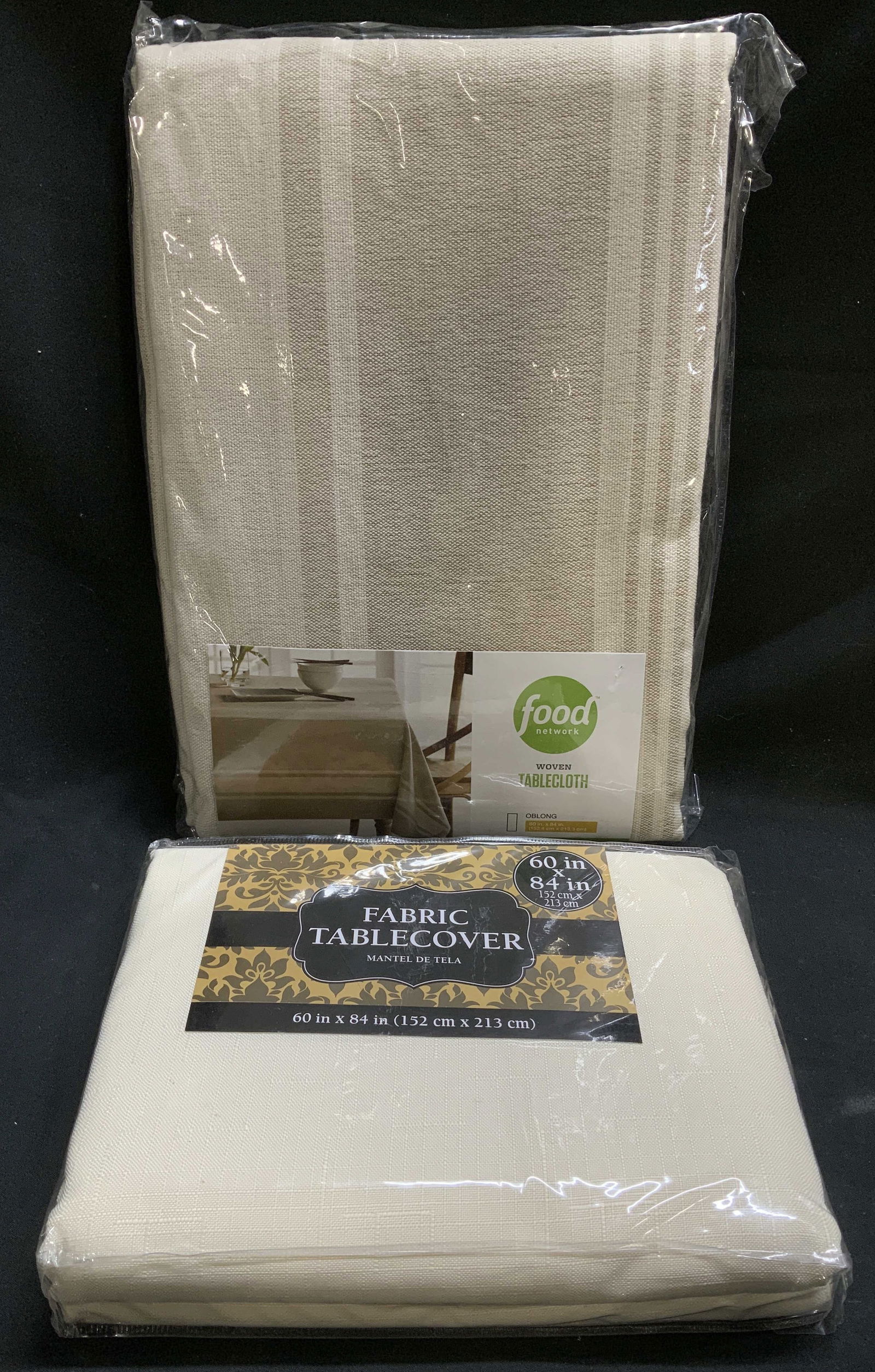 Lot 2 Fabric & Woven Tabecloth NIP AMSCAN+: Lot includes, 1 AMSCAN Fabric table cover size 60in x 84in. (Made in India) & 1 Food Network woven tablecloth oblong size 60in x 84in. (Made in India). New in plastic. Has not been inspected out of pl