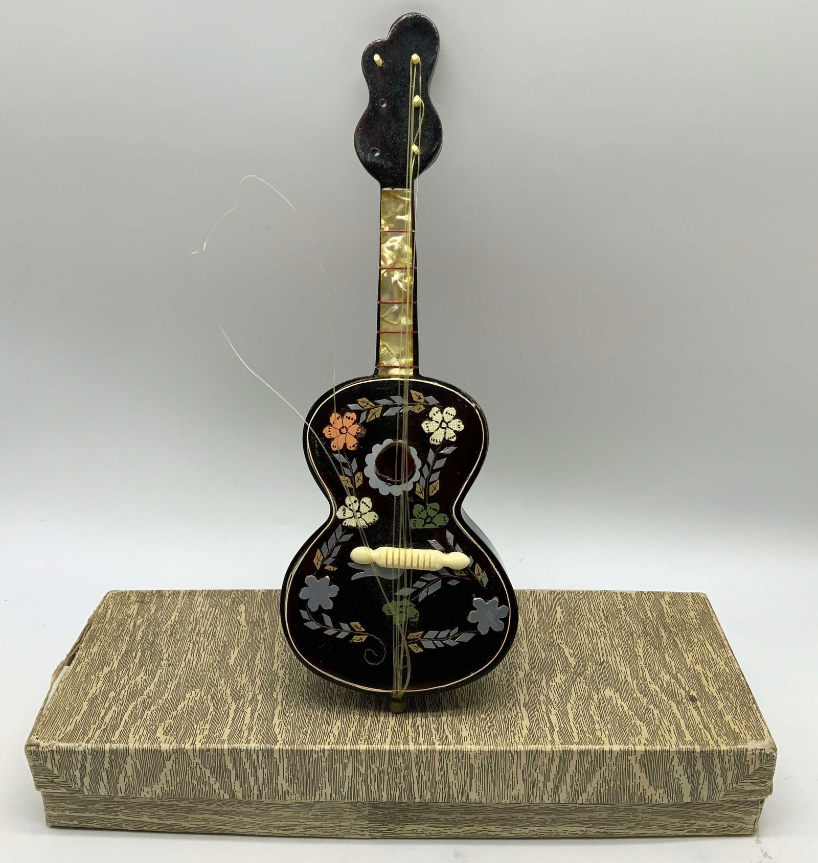 Vtg Inlaid Floral Motif Guitar Musical Box: Vintage guitar musical box features intricate inlaid floral details on body & silver toned accents. Composite material. Comes with box. No visible signature or markings. Surface wear consistent to age