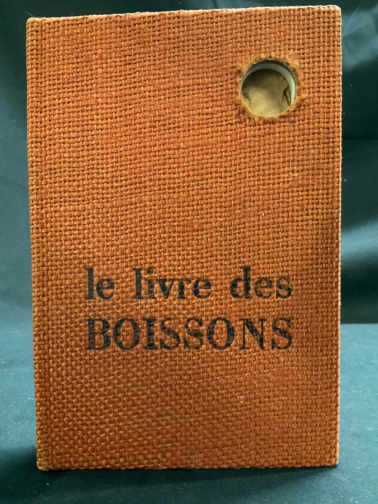 1970 Le Livre Des Boissons French Bk LEQUENNE: The Book of Drinks by Fernand Lequenne. Le Livre Des Boissons par Fernand Lequenne. Robert Morel Editeur. Copyright 1970. Book features a textured burlap cover & small circular cutout that is held tog