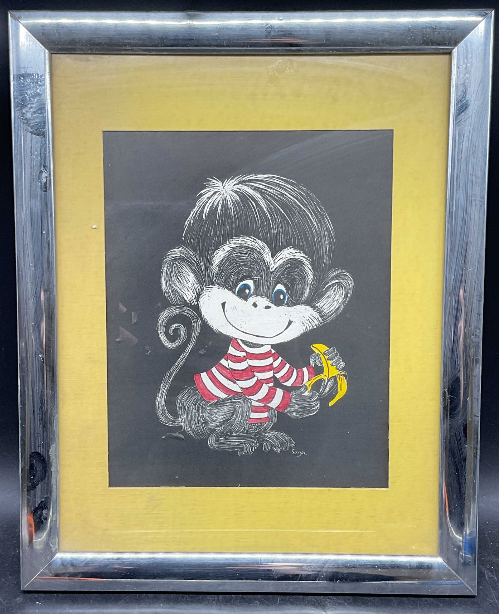 Framed Sonya Monkey & Banana Illustration: Framed and matted illustration. Artist name printed lower right, Sonya. Monkey wearing red striped shirt holding banana. Silver tone frame. Not examined out of frame. Frame measures approx. 15.5 x 12.