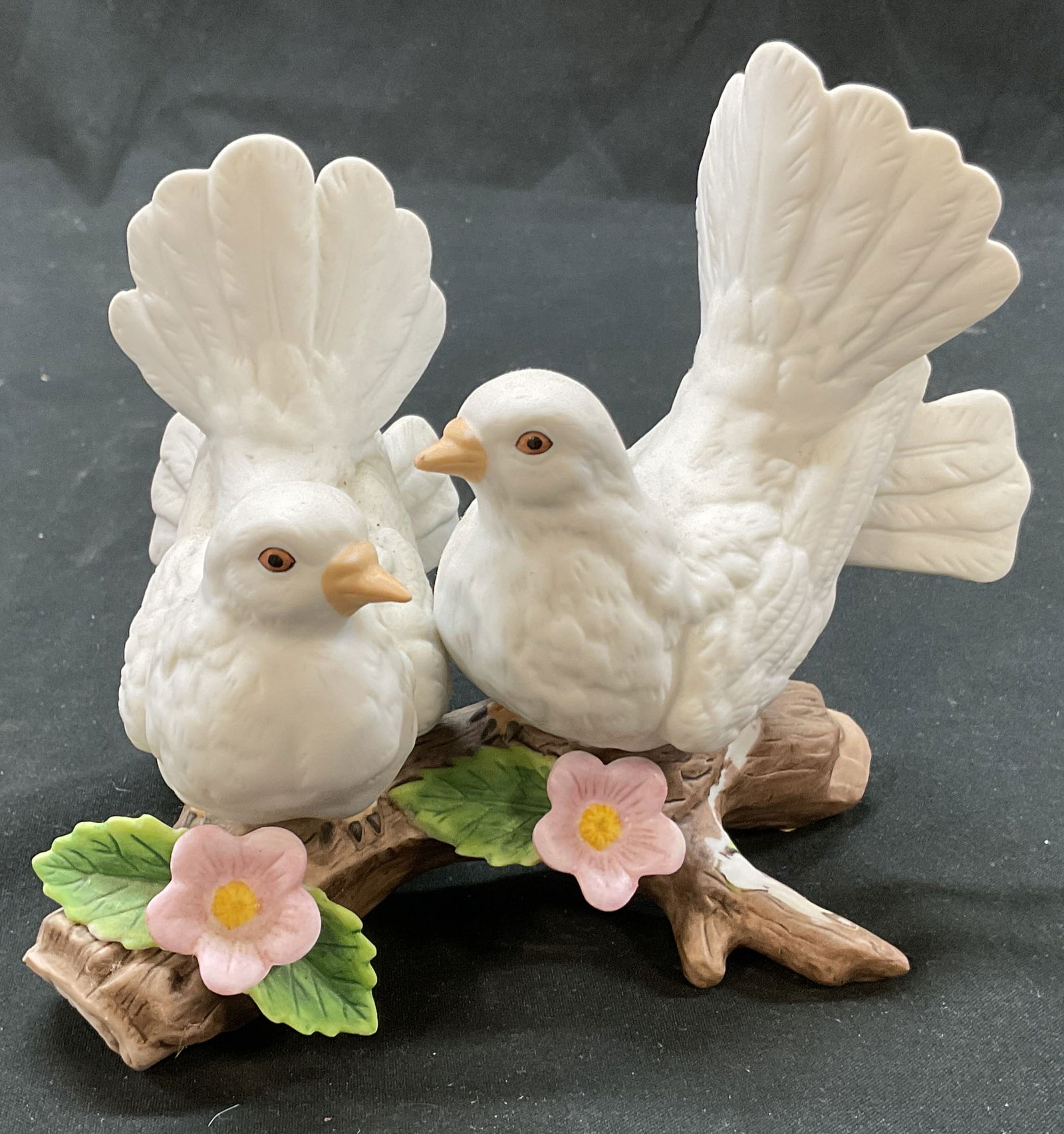 Homco Courtship Doves Porcelain Figurine: Homco Courtship Doves porcelain figurine. Marked Homco on underside. Model number 1453. Two white doves perched on a log adorned with pink floral motifs and green leaf motifs. Detailed features and te