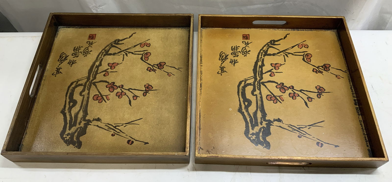 Pair Pier 1 Blossom Motif Wooden Serving Trays: Lot includes, 2 Pier 1 wooden serving tray features hand-painted blossom motifs & Chinese characters. Surface wear consistent to age, use & exposure. Measurements: length 15in x width 15in x height 2i