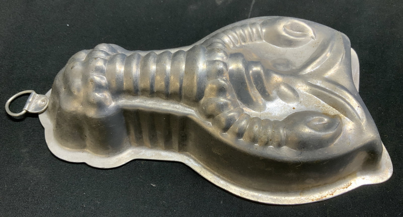 Vntg Lobster Metal Mold HONG KONG: Vintage lobster-shaped metal mold, featuring textured details. Features hook. Surface wear consistent to age, use & exposure. Measurements: length 6.5in x width 3.8in x height 1.5in. Vintage lobster m