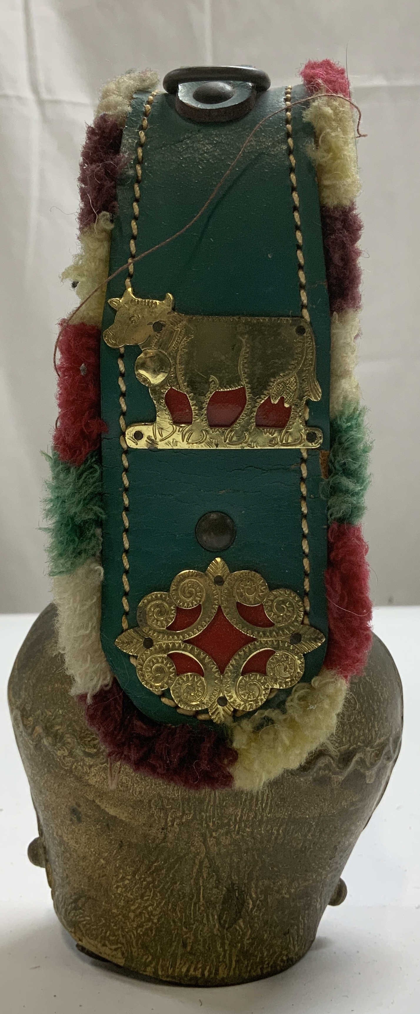 Vtg Swiss Style Brass Cowbell W Leather Strap: Vintage Swiss style cowbell is brass material & features a green leather strap with gold toned adornments. Colorful felt trim on strap. No visible signature or markings. Surface wear consistent