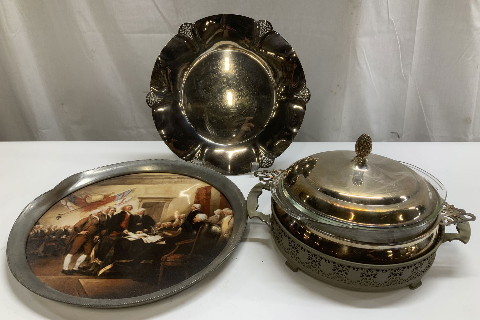 3 WM Rogers, Revere, Sheffield Silver Co Tableware: Lot includes, 1 WM Rogers silver plated scalloped serving platter, 1 Revere Pewter tray depicting the signing of the Declaration of Independence & 1 Sheffield Silver Co. lidded casserole dish.