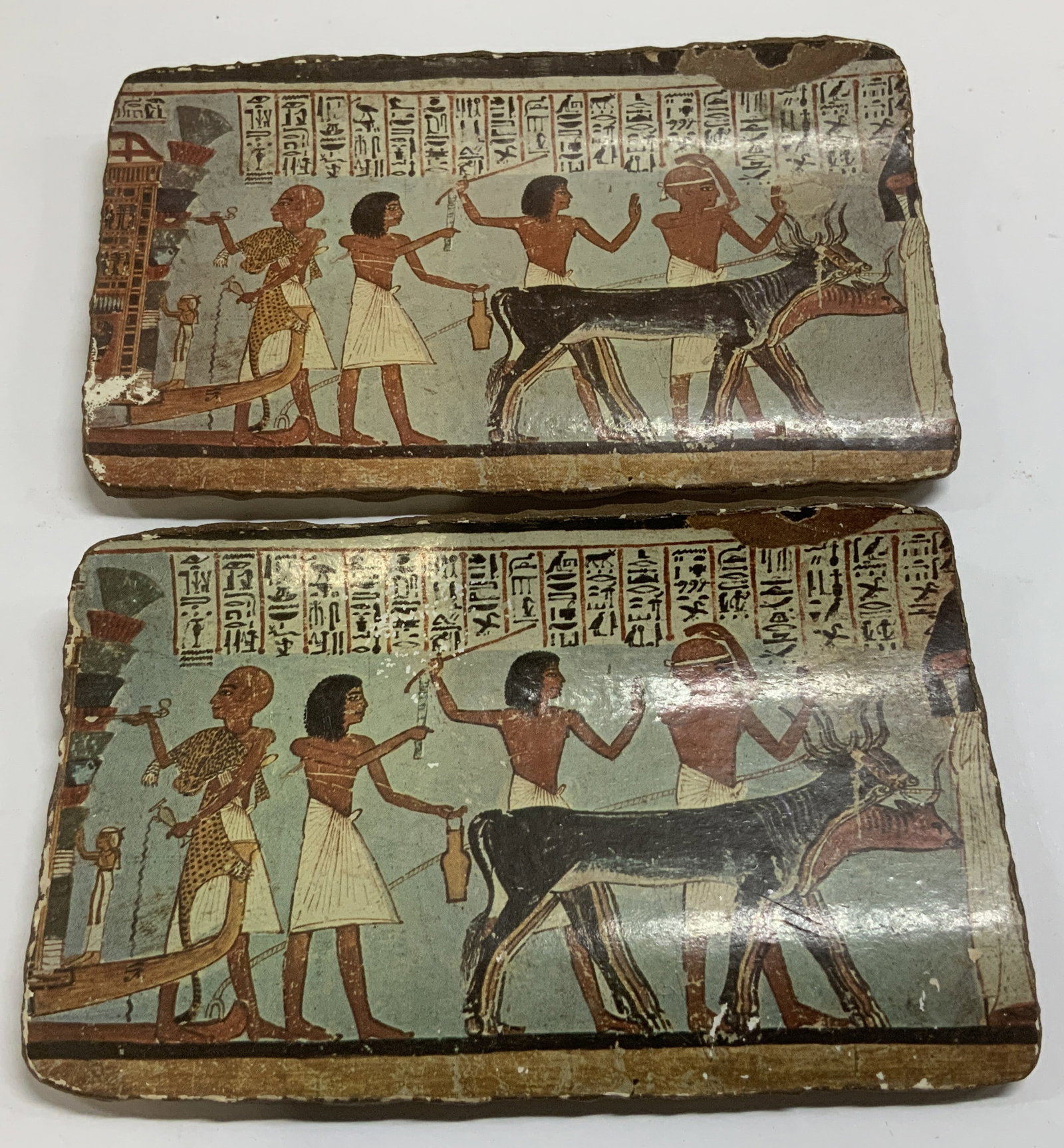 Lot 2 Vtg Deco Egyptian Style Plaques: Lot includes, 2 vintage rectangular decorative plaques depicting an Ancient Egyptian scene with figures & animals. Hieroglyphics at top. Ceramic material. No visible signature or markings. Surface wea