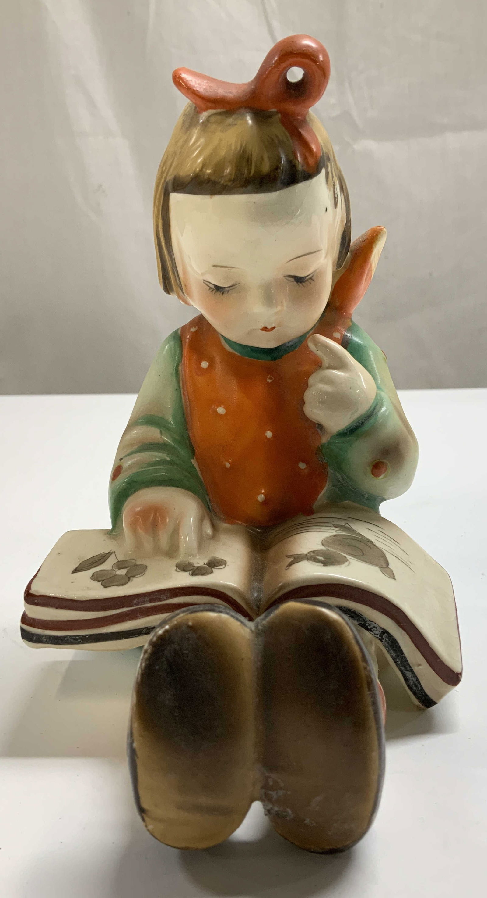 Vtg Gold Castle Girl Reading Book Fig JAPAN: Vintage ceramic figurine depicting a young girl reading a book. Shades of green, orange & brown. Signed & marked on underside. Reads, GOLD CASTLE. MADE IN JAPAN. Surface wear consistent to age, use &